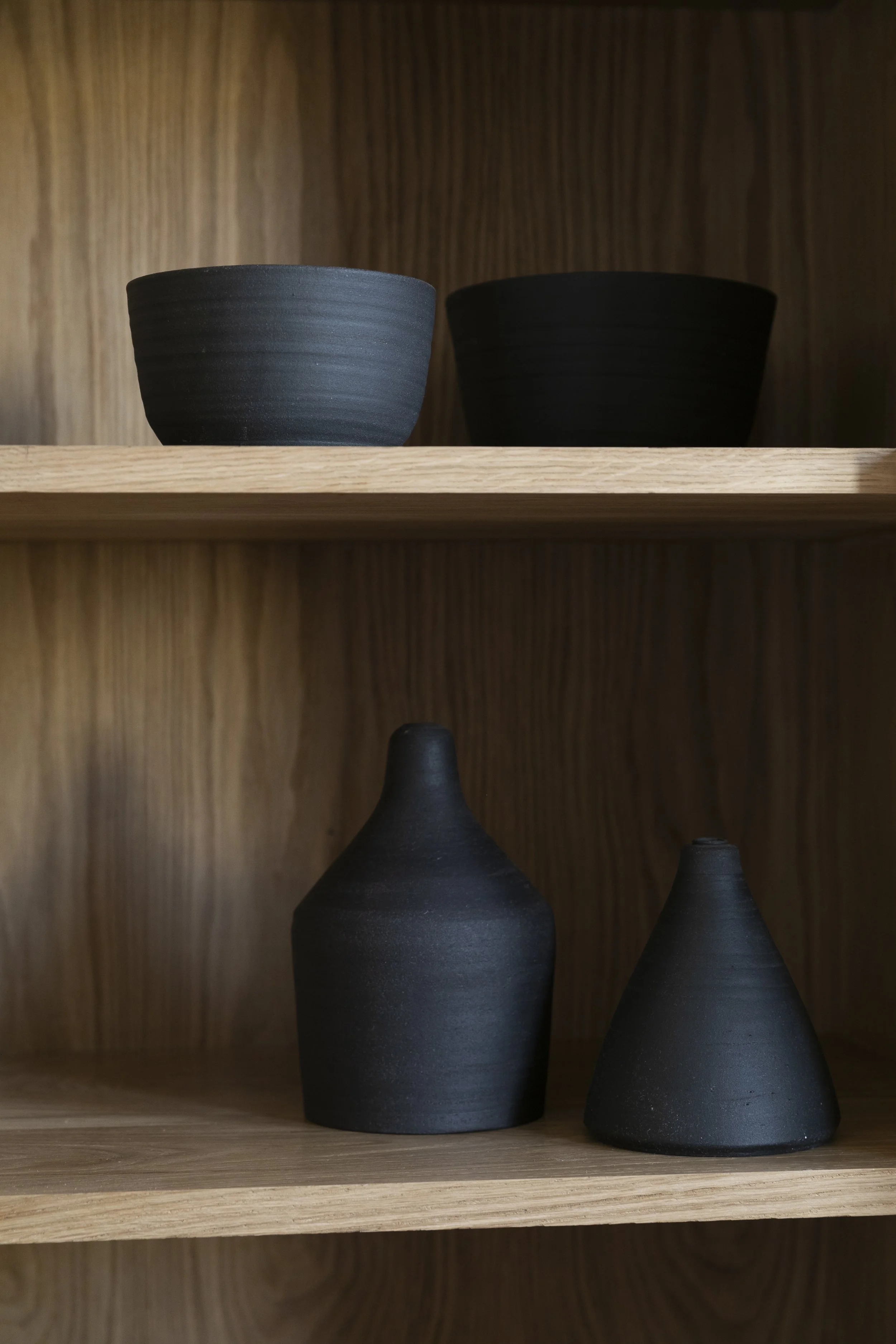 Organisch geformte Keramikschalen auf einem Regal.