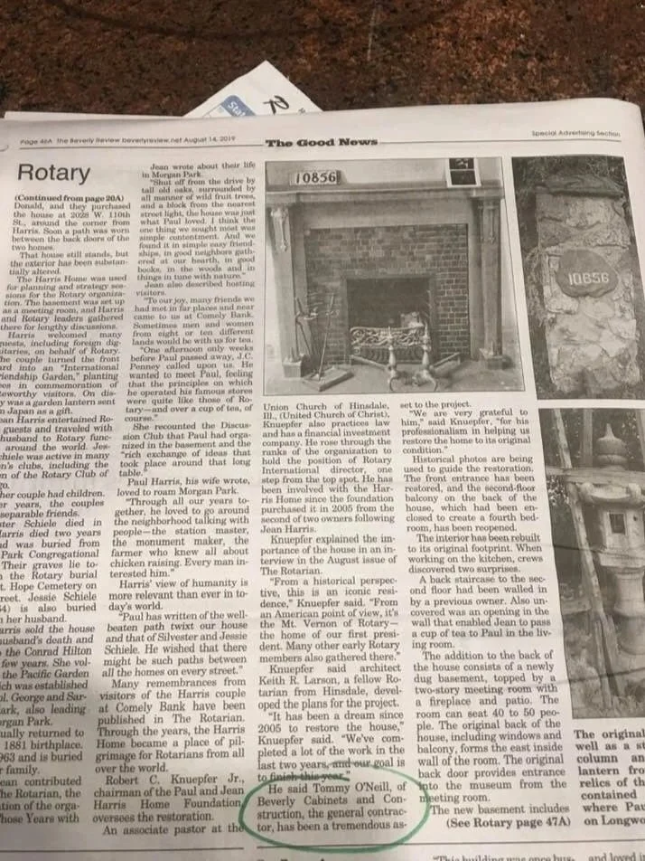 Black and white newspaper article titled 'The Good News' with a photo of a house with a porch, and a smaller photo of a stone plaque with the number 10856.