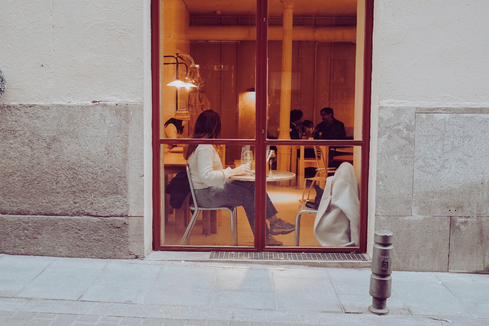 Klant zit in een restaurant, gezien door het raam