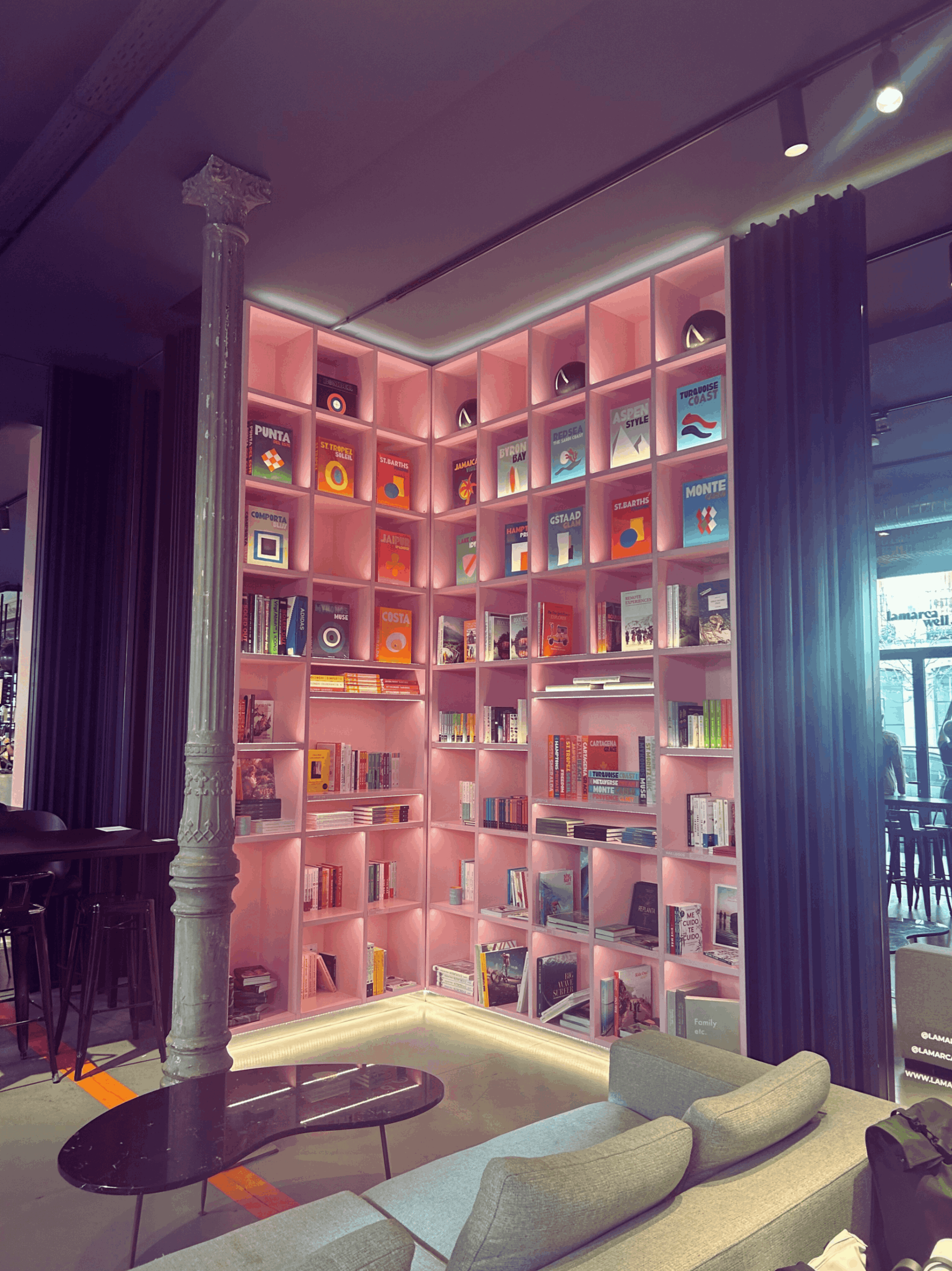 Boekwinkel met roze boekenkast en zithoek