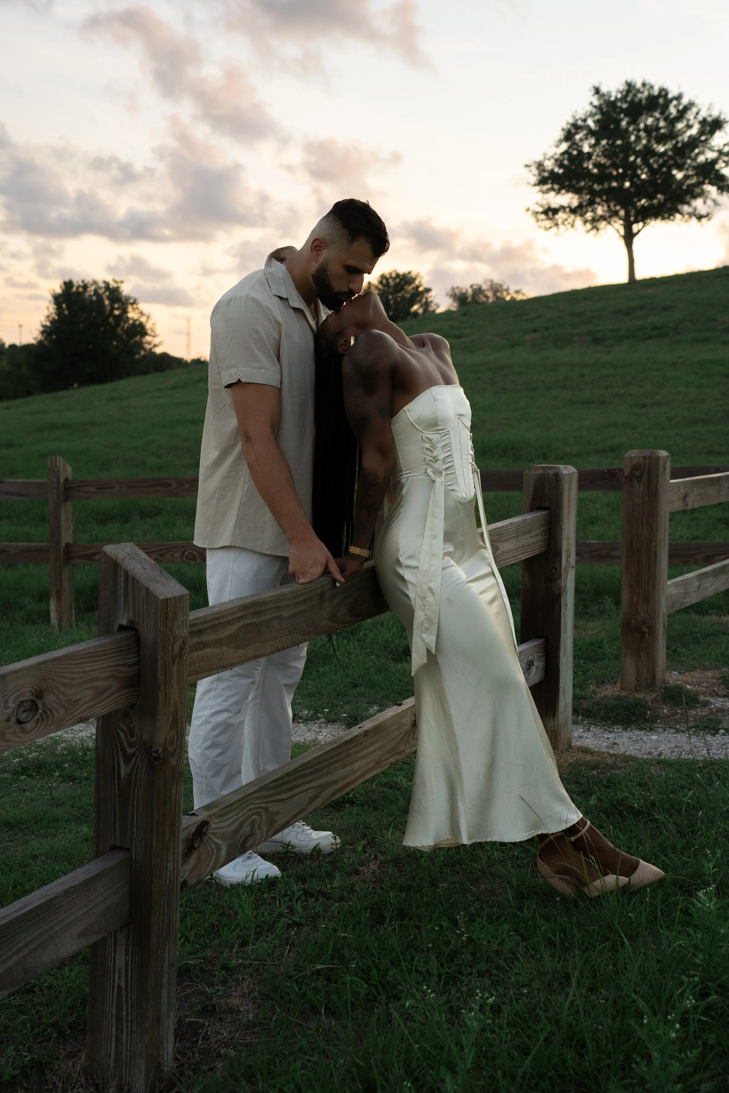 Couple embracing beside a wooden fence during a sunset couples photoshoot at Celery Fields in Sarasota, Florida.