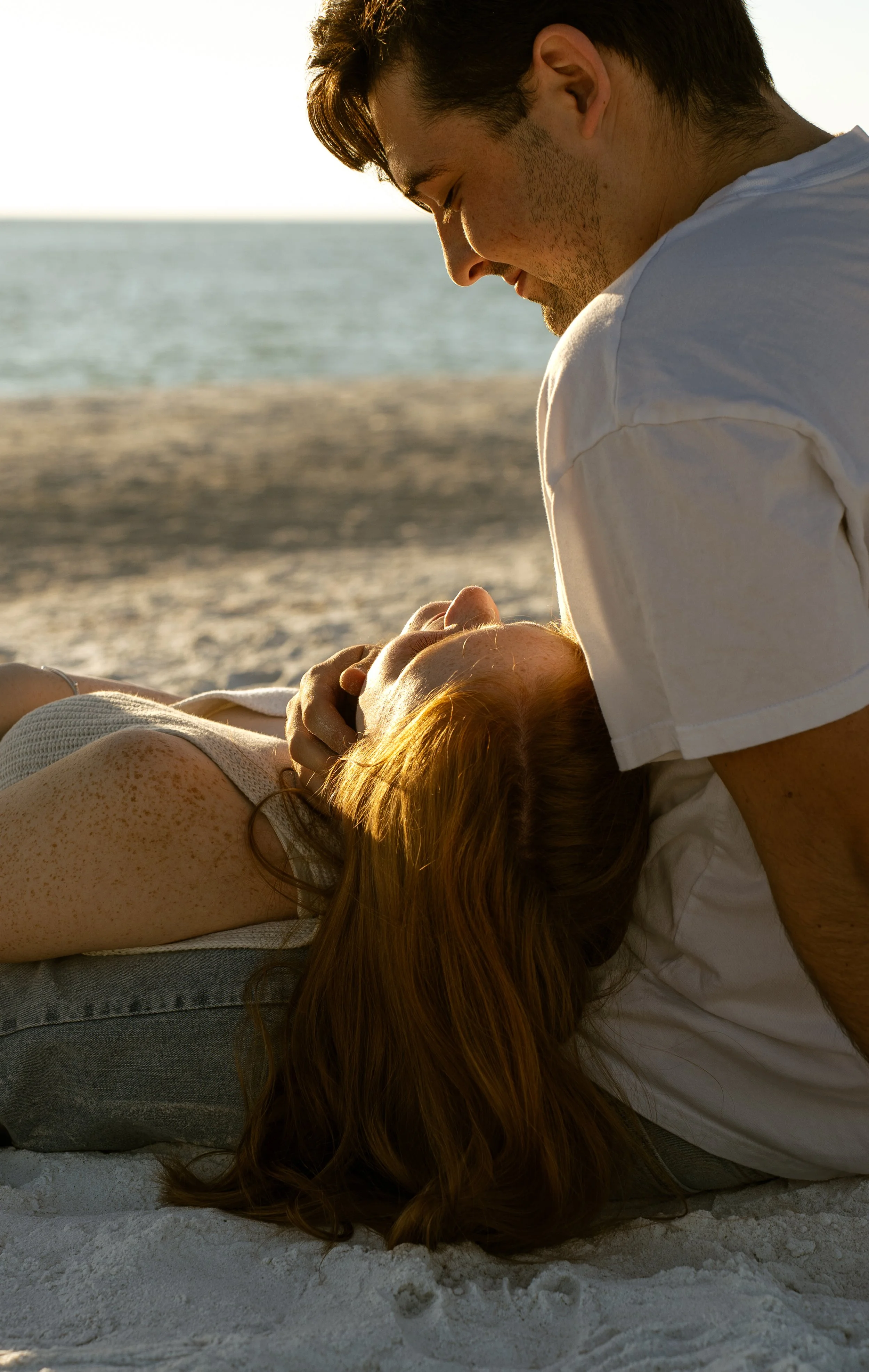 Couple relaxing together on the beach during a sunset couples photography session on Anna Maria Island, Florida.