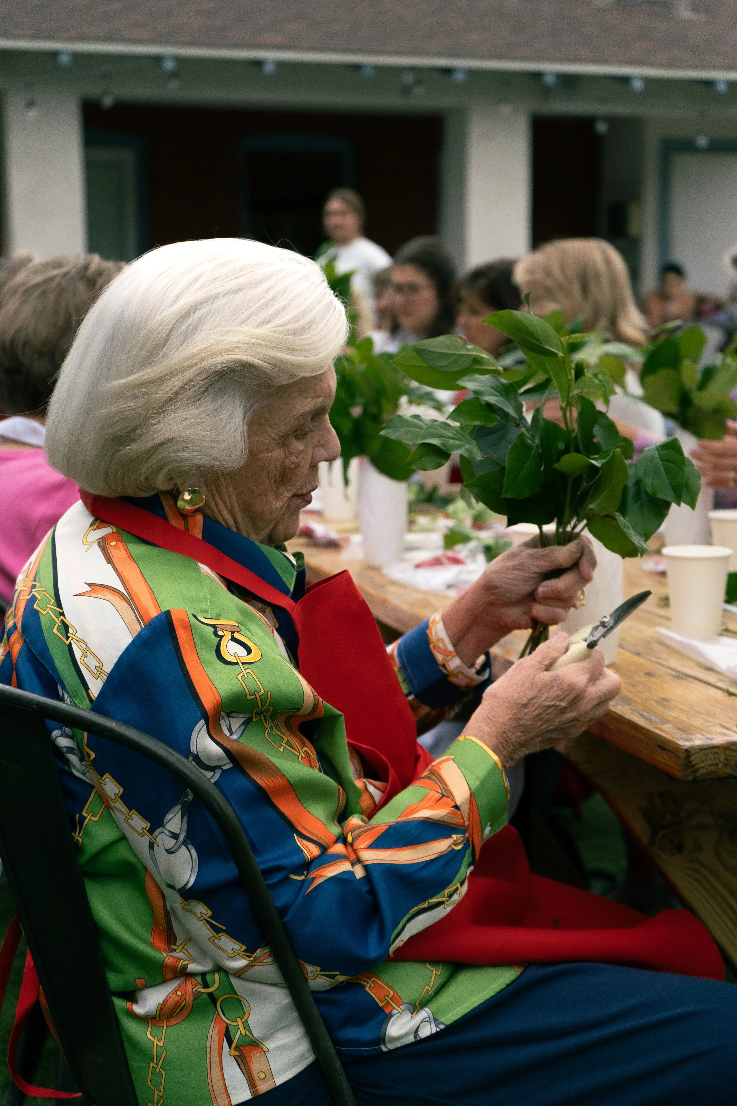 Guest creating a flower arrangement during a creative community event in Sarasota, Florida.