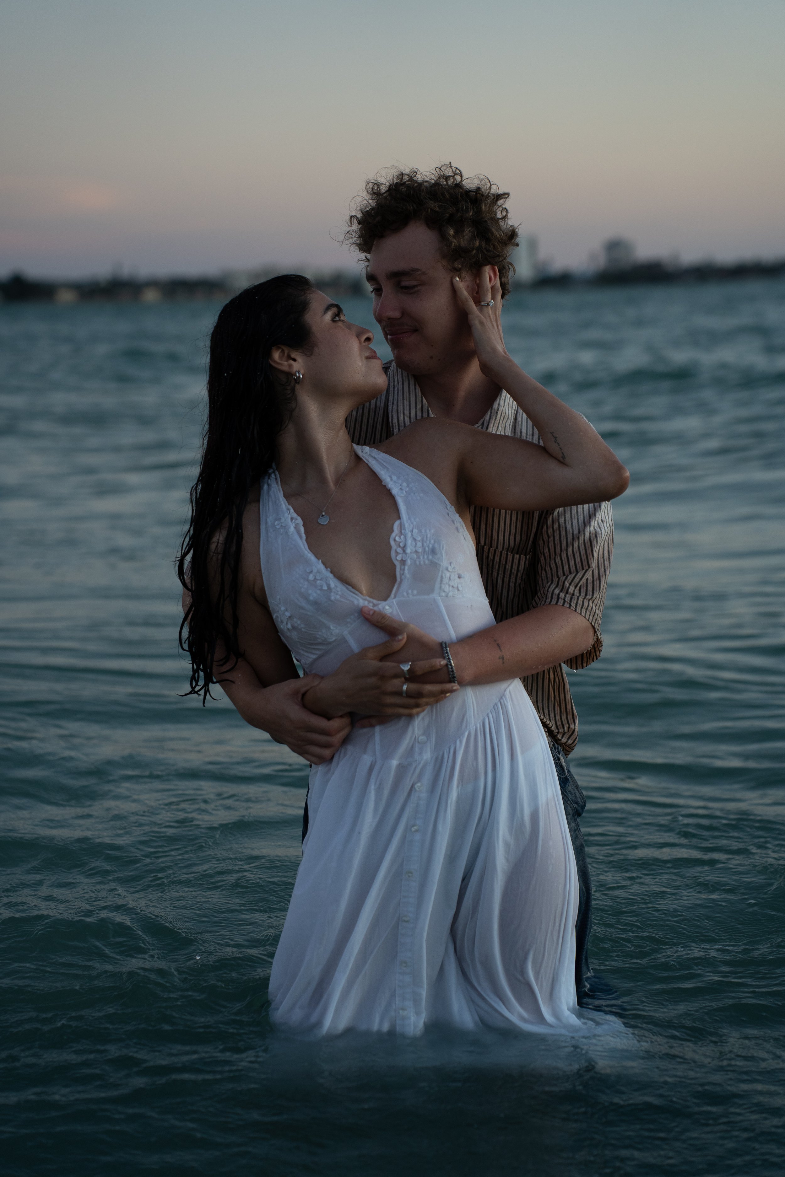 Couple embracing in the water during a romantic photoshoot at Lido Beach in Sarasota, Florida.