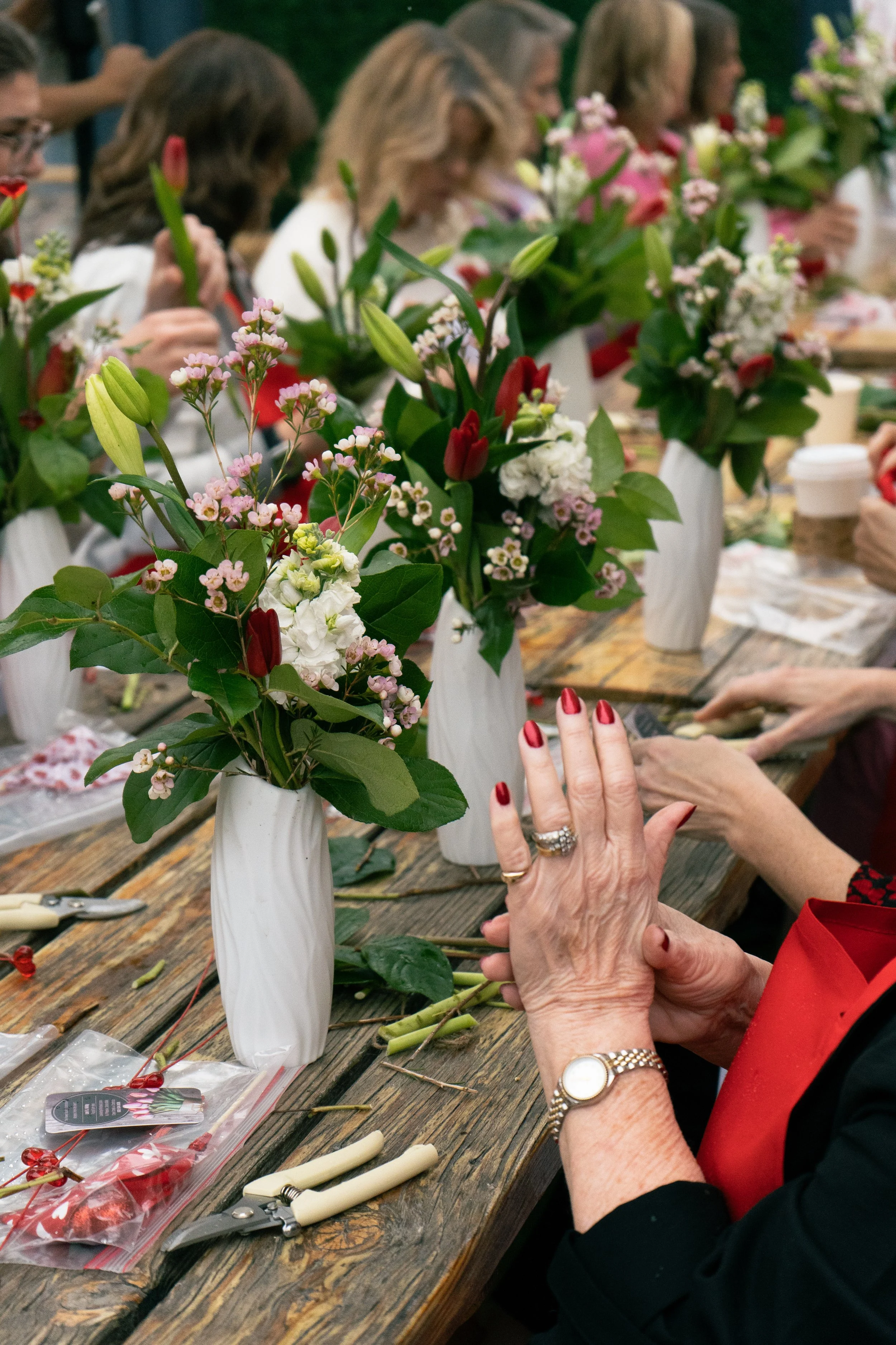 Guests creating floral arrangements during a Galentine's workshop in Sarasota.