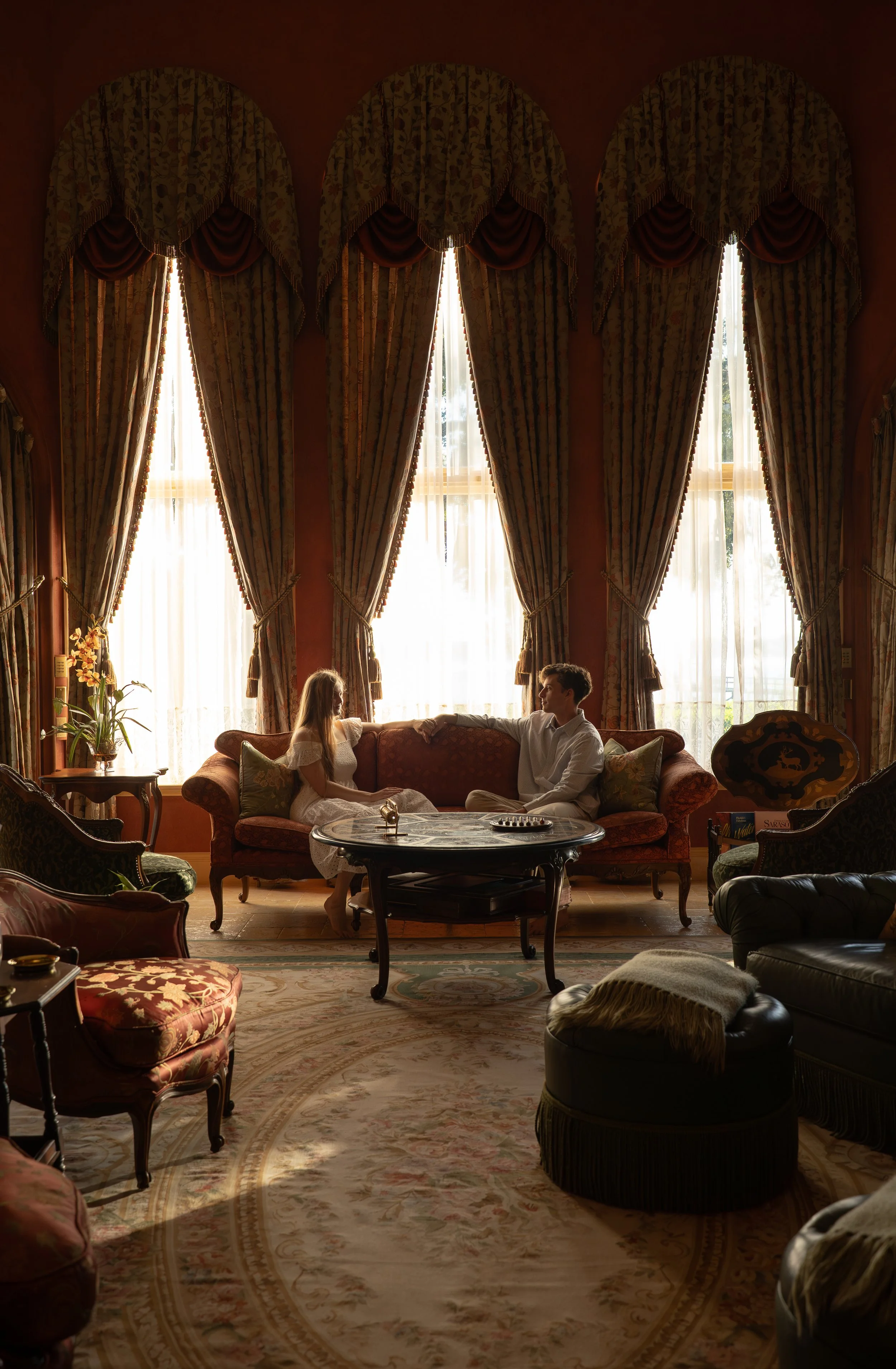 Couple seated together in an elegant vintage interior during a romantic editorial couples photography session in Sarasota, Florida.