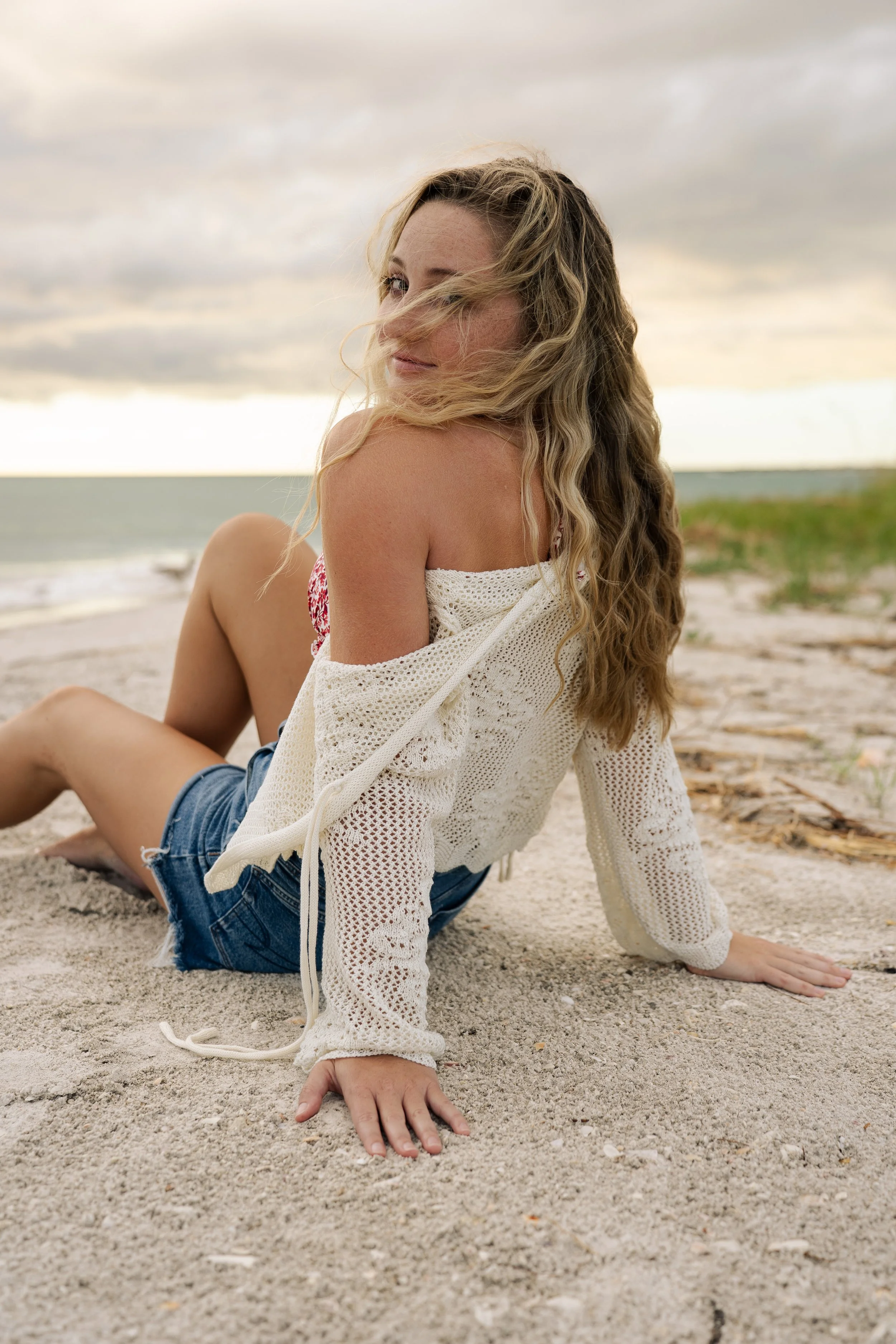 Woman sitting on the sand during a beach portrait session at Lido Beach in Sarasota, Florida