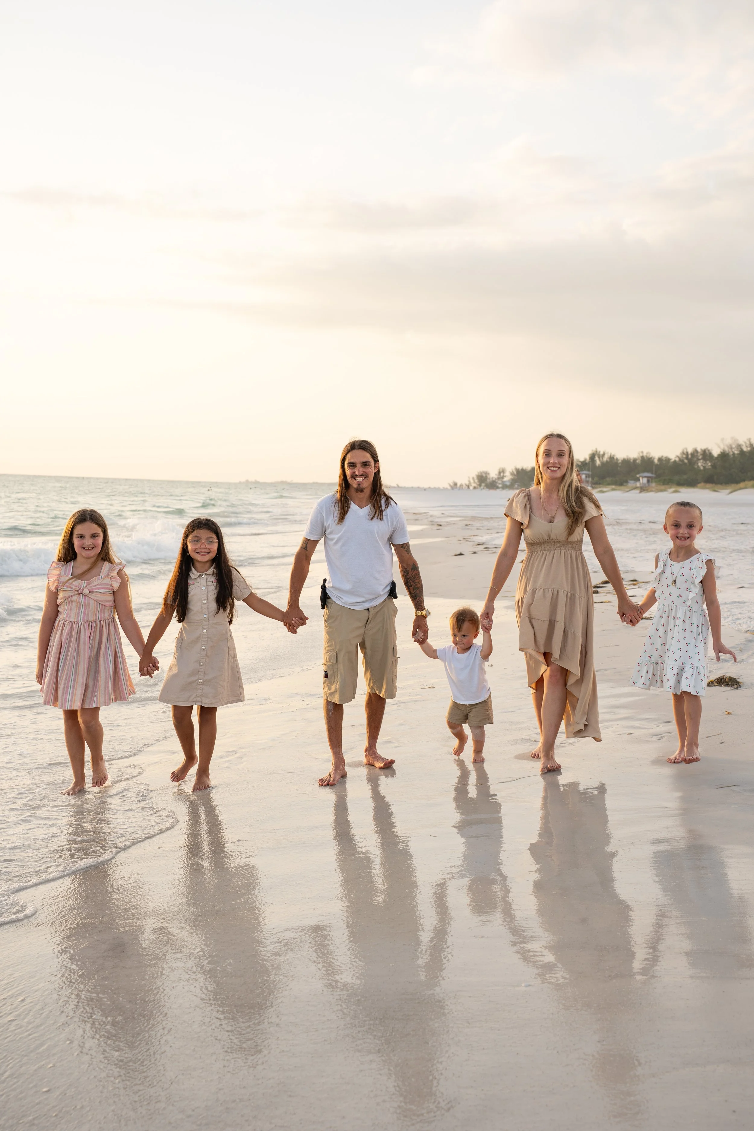 Family walking along Coquina Beach during a sunset family session