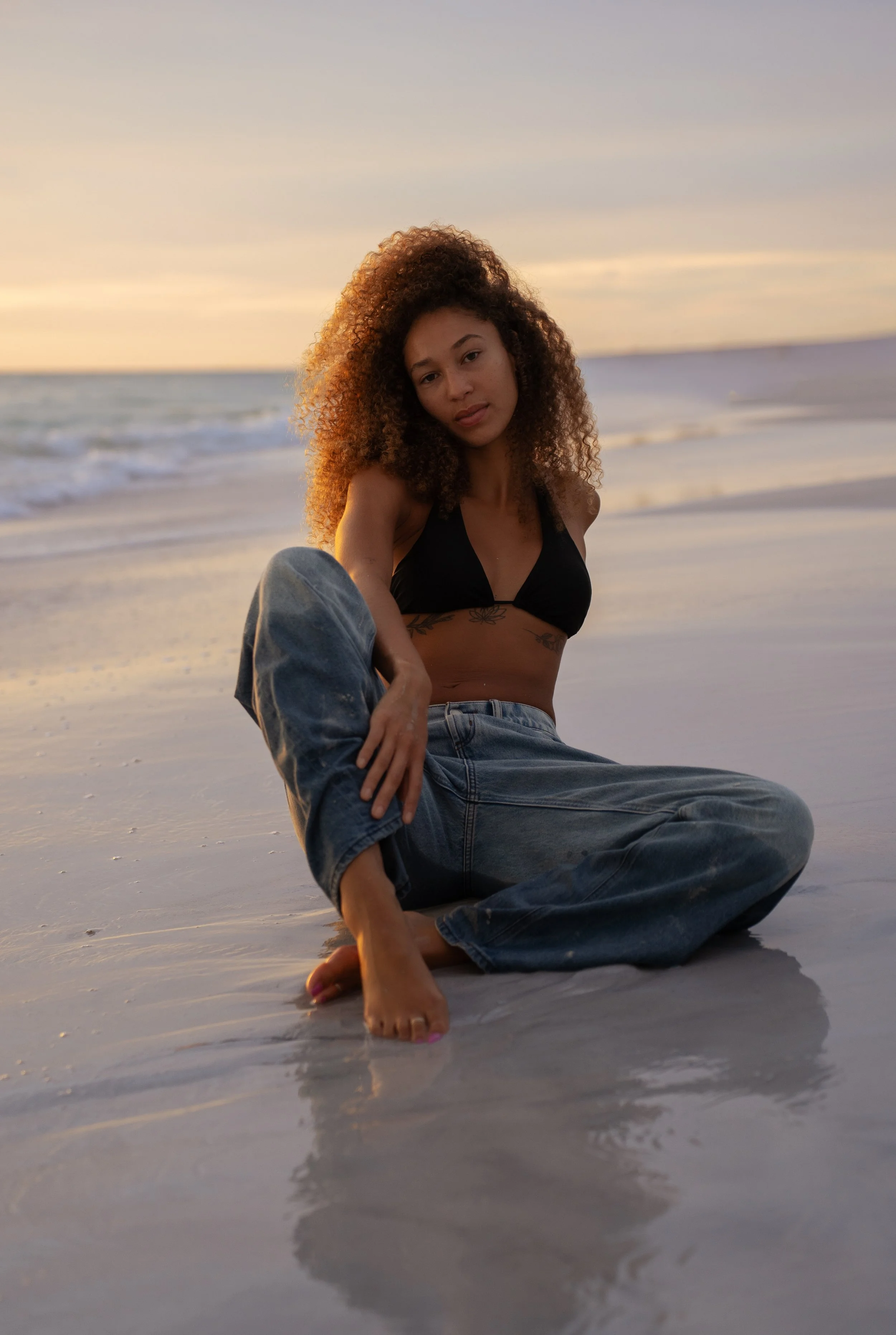 Woman posing along the shoreline at sunset during a portrait session on Anna Maria Island, Florida