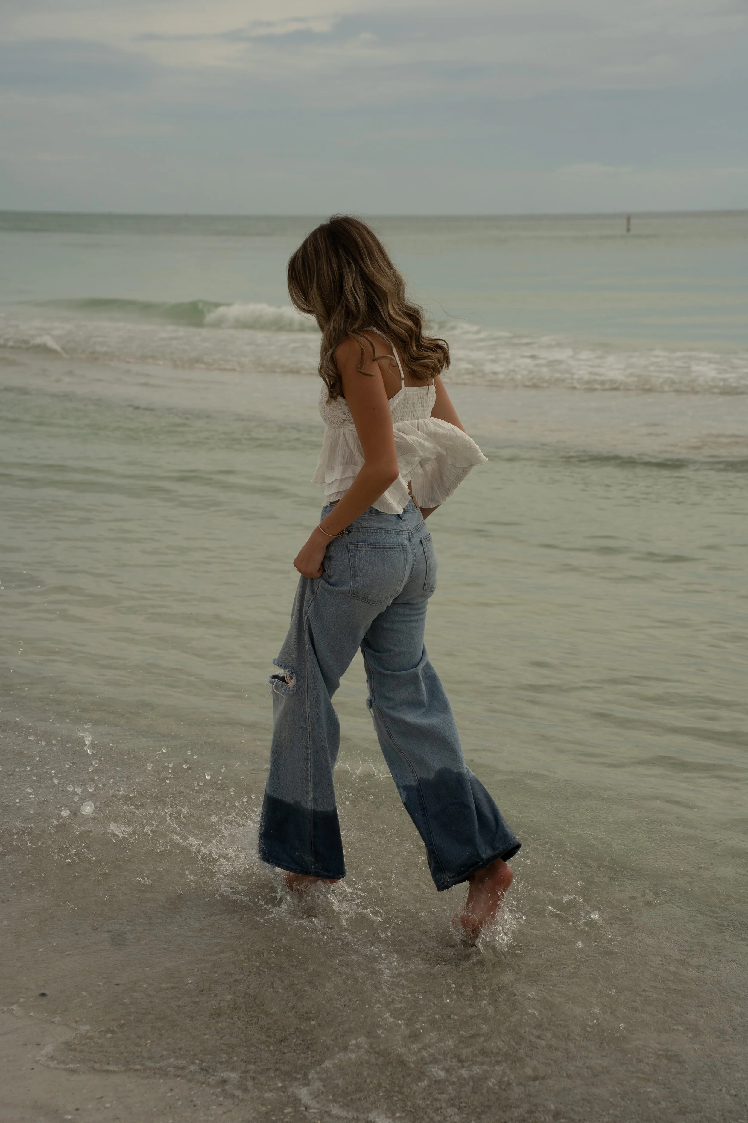 Senior portrait walking along Coquina Beach on Anna Maria Island