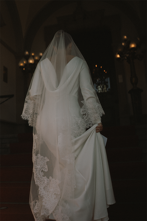 Bride walks up the stairs in her wedding dress in front of Schloss Lieser.