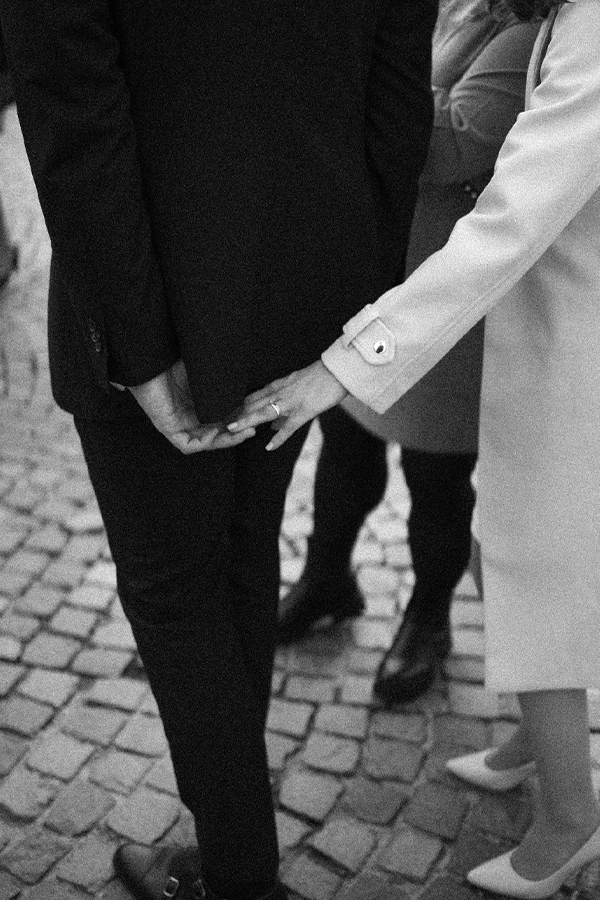 Bride and Groom are holding hands, detail shot of the wedding rings.