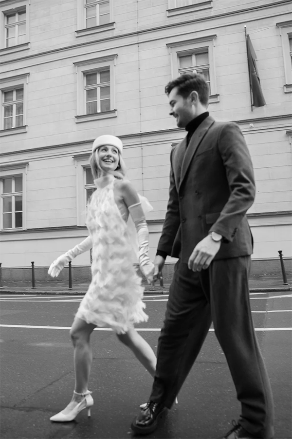 Bride and groom walking on the street. The bride is wearing a short dress from Marylise bridal.