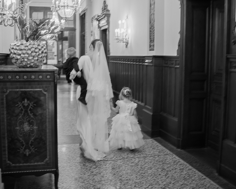 Bride walks the hallway of Schloss Lieser with her children.