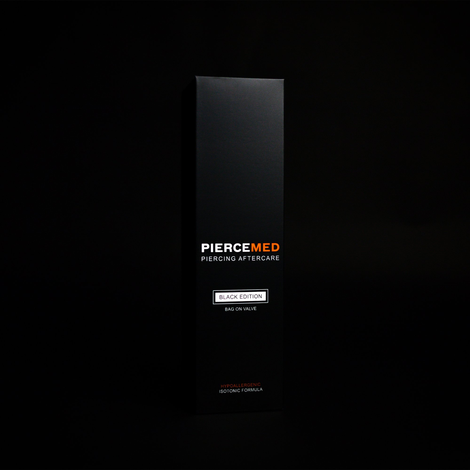 A black box packaging for PierceMed piercing aftercare product, labeled as Black Edition with a bag on valve, hypoallergenic, and isotonic formula, set against a dark background.