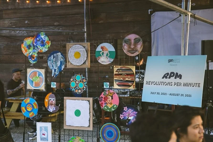 Display of various colorful circular art pieces and paintings at an art event titled 'Revolutions Per Minute' on July 30 to August 29, 2021.
