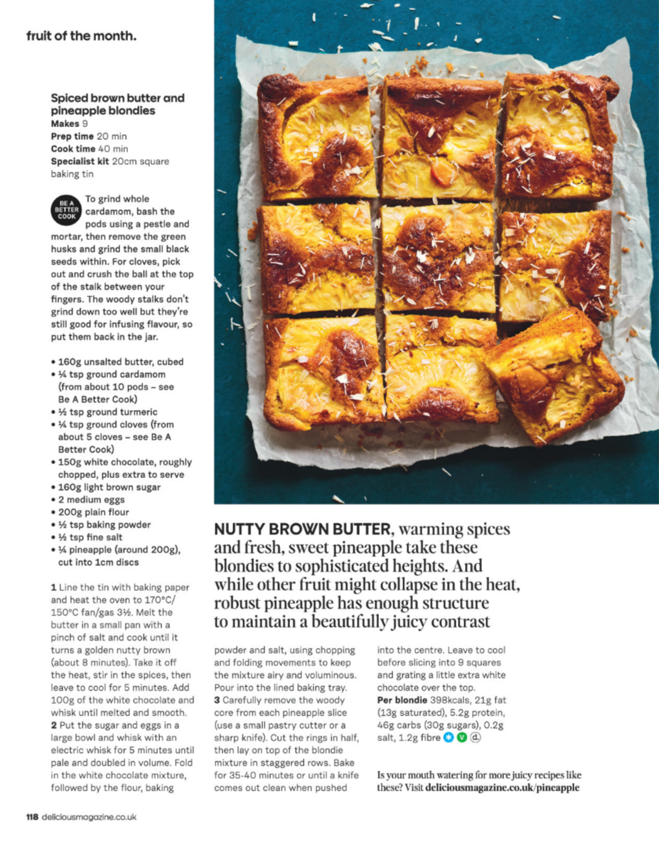 Baked pineapple blondies cut into nine squares with a golden brown crust and chunks of pineapple on top, sprinkled with shredded coconut.