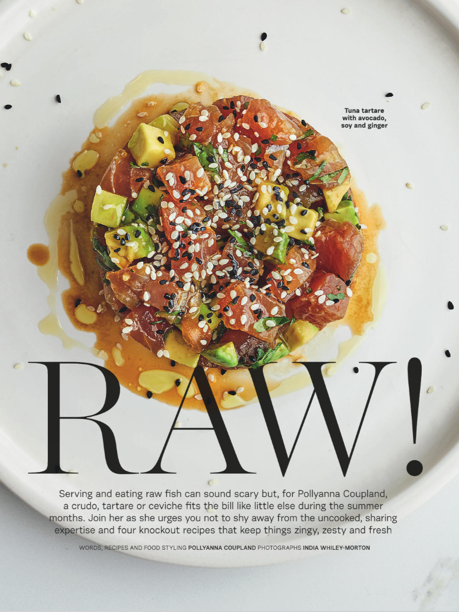 Close-up of a plate with tuna tartare topped with avocado, sesame seeds, and herbs, drizzled with a sauce, and garnished with black and white sesame seeds.