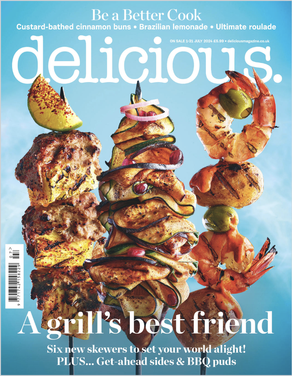 Magazine cover featuring three tall food skewers with grilled chicken, vegetables, shrimp, and garnish, against a light blue background.