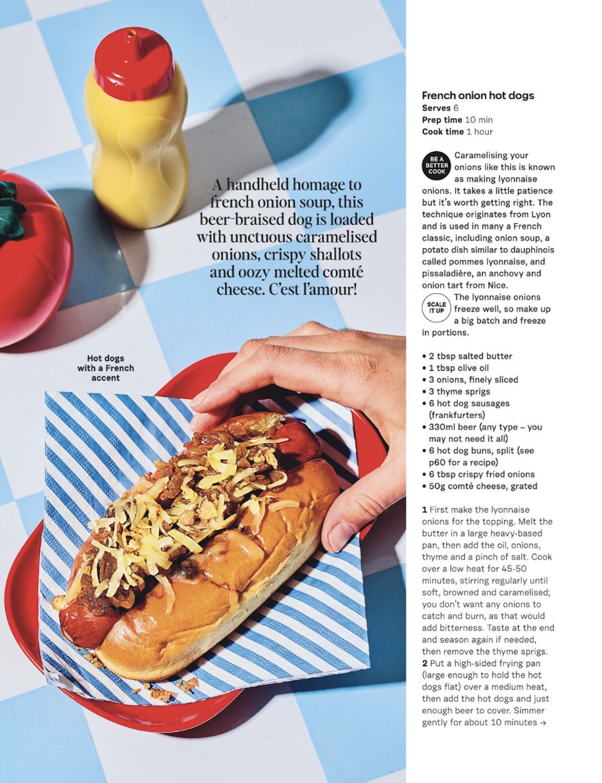 A page from a recipe magazine featuring a hot dog with caramelized onions, grated cheese, and crispy fried onions, served in a bun on a striped paper inside a red dish. The background has a blue and white checkered pattern, and there are condiments, 