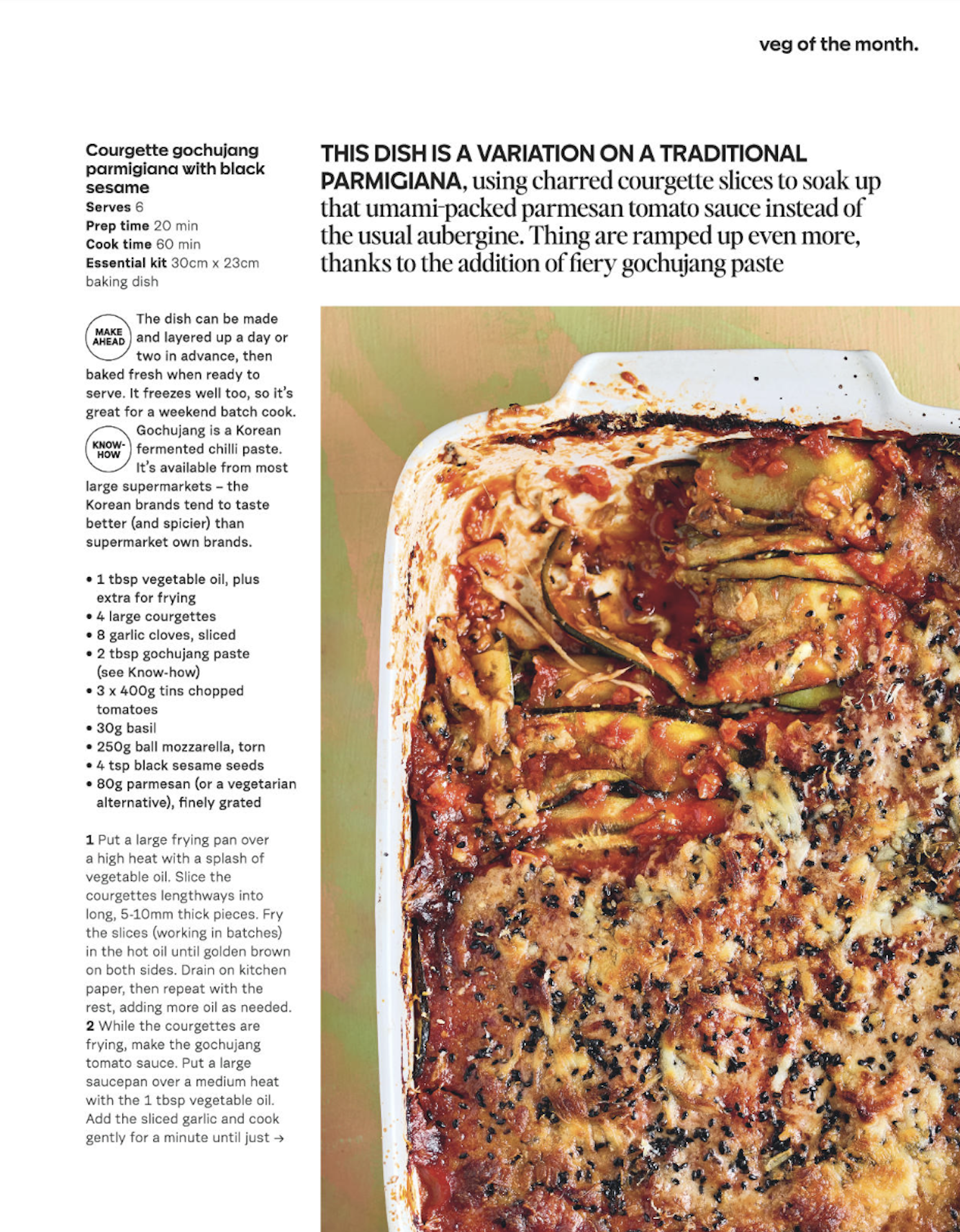 Baked dish of gochujang parmesan with charred courgette slices topped with black sesame seeds and melted cheese in a white baking dish.