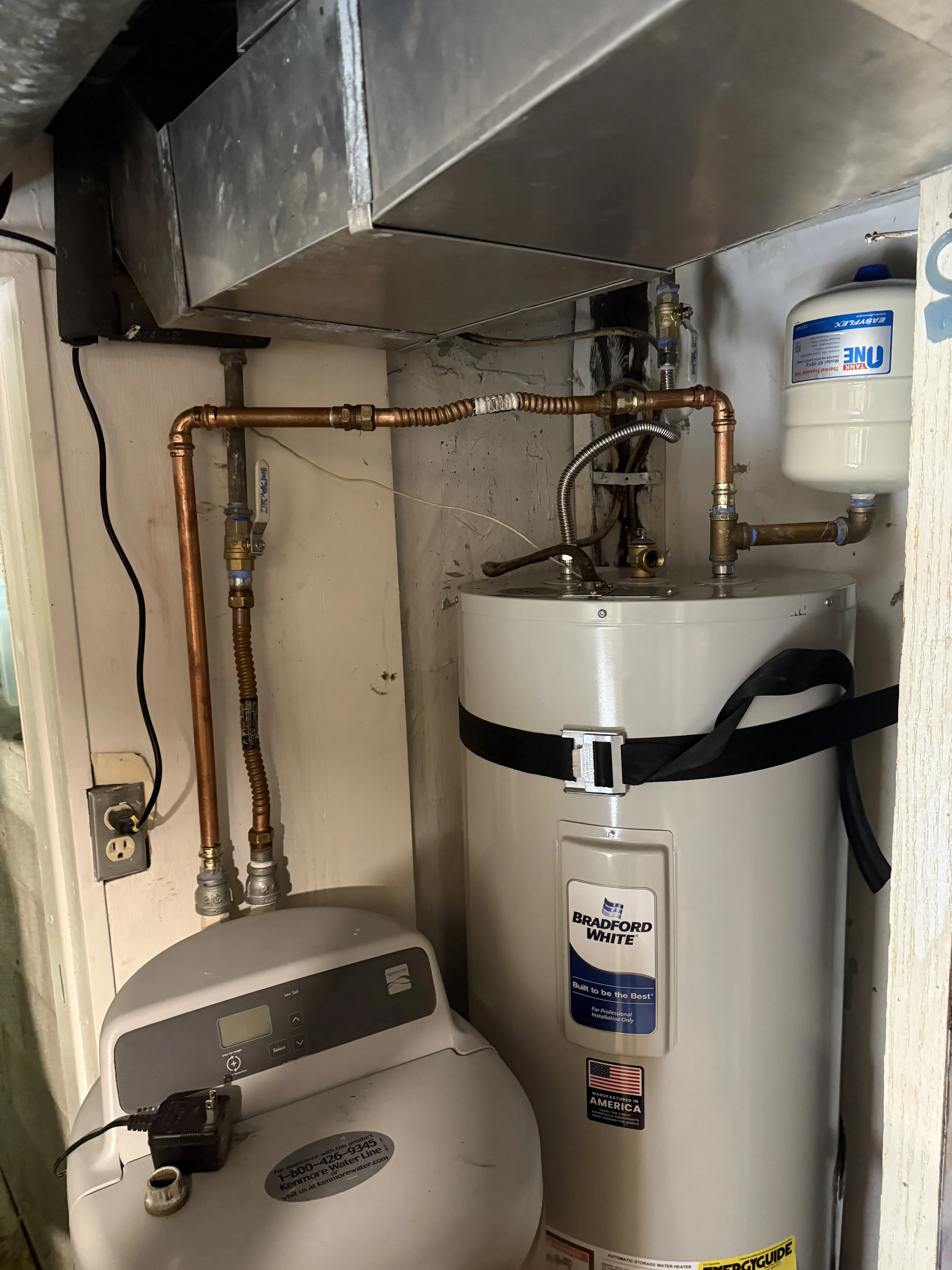 A room with a water heater and water softener.