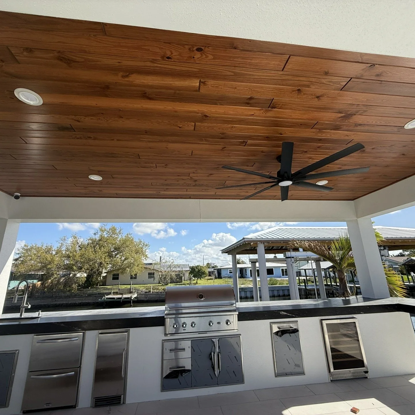 This covered patio started as exposed trusses and plywood &mdash; now it&rsquo;s a fully finished outdoor living space with tongue &amp; groove ceiling, recessed lighting, custom outdoor kitchen, and clean modern lines throughout.
Outdoor spaces aren