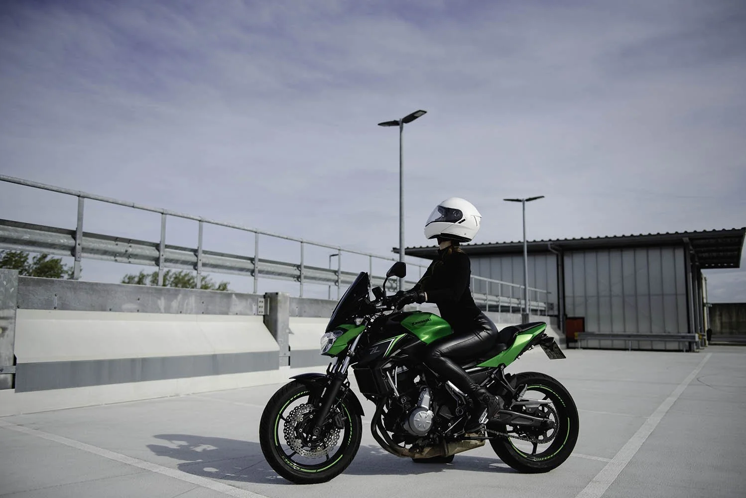branding photoshoot of motor biker, motorbike, model, wearing riding outfit photo shooting on the roof 