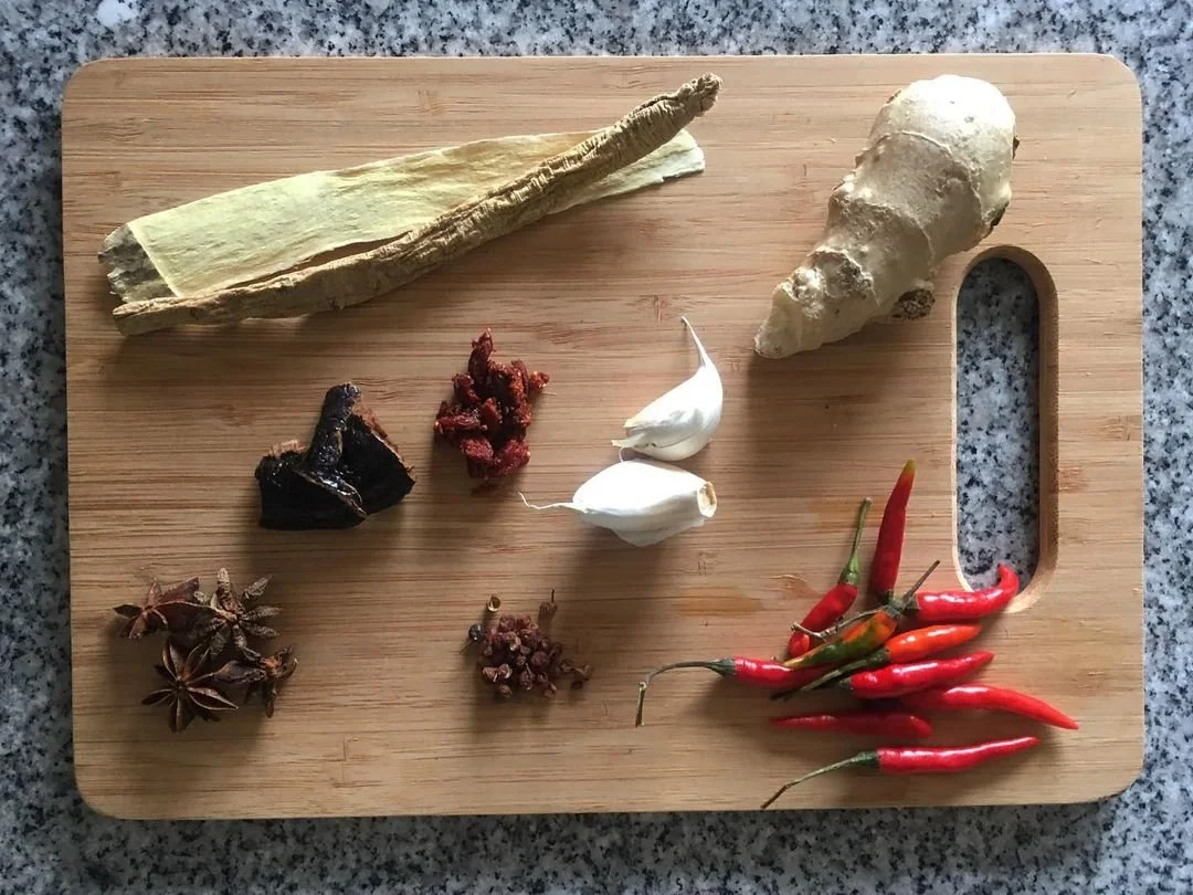 cooking ingredients and herbs on a wooden cutting board