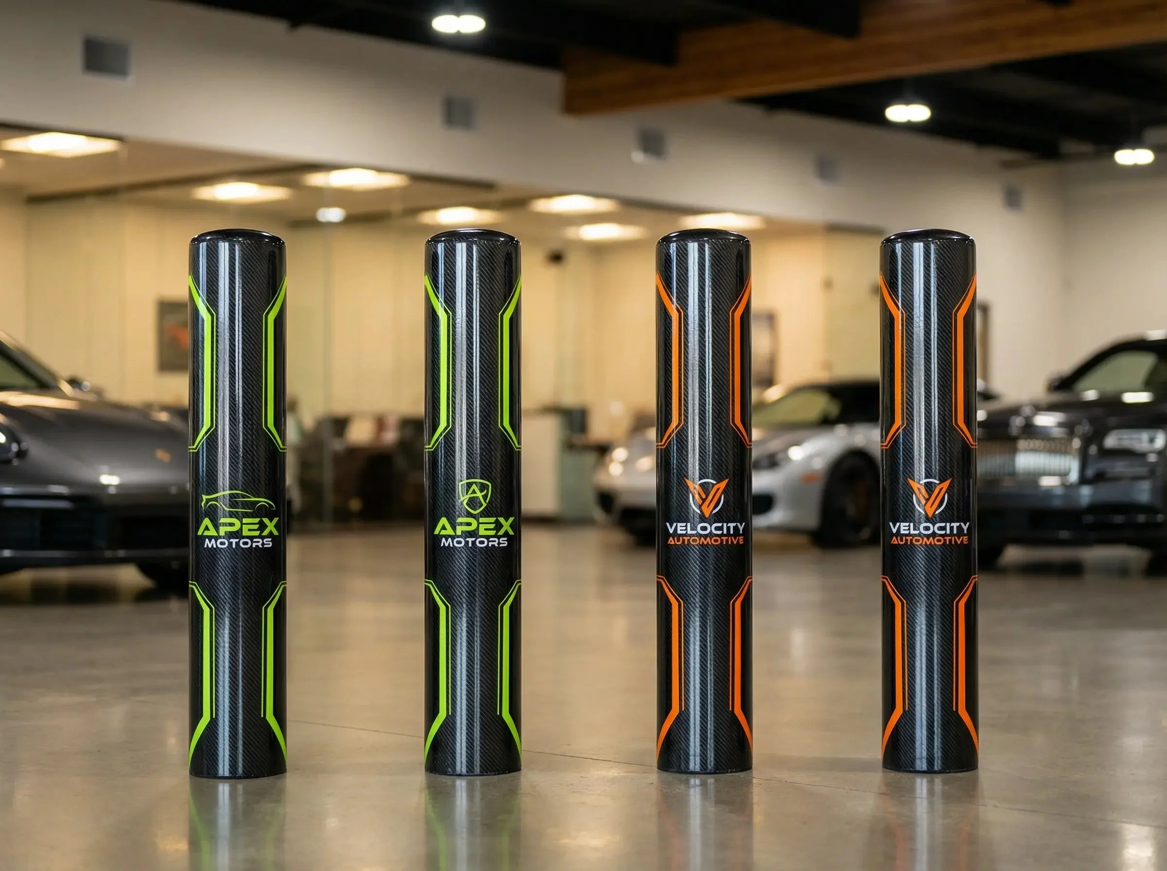 Four cylindrical car performance parts, two with green accents and two with orange accents, standing upright on a polished floor in an indoor setting with luxury cars in the background.