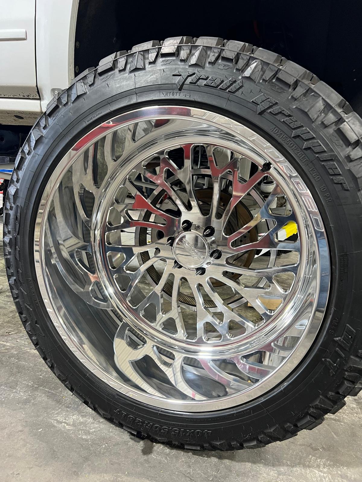 Close-up of a customized truck wheel with a chrome rim and off-road tire.