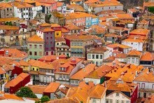 Colorful buildings with orange rooftops in a hillside neighborhood.