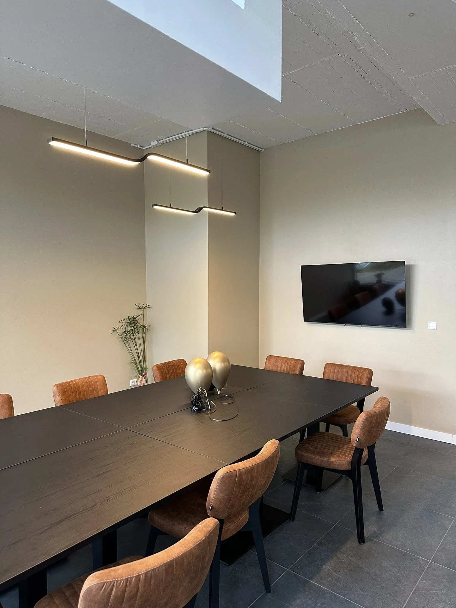 Strak weggewerkte tv-aansluiting en led-verlichting in de eetruimte van een kookstudio, gerealiseerd volgens de Stoker Standaard.