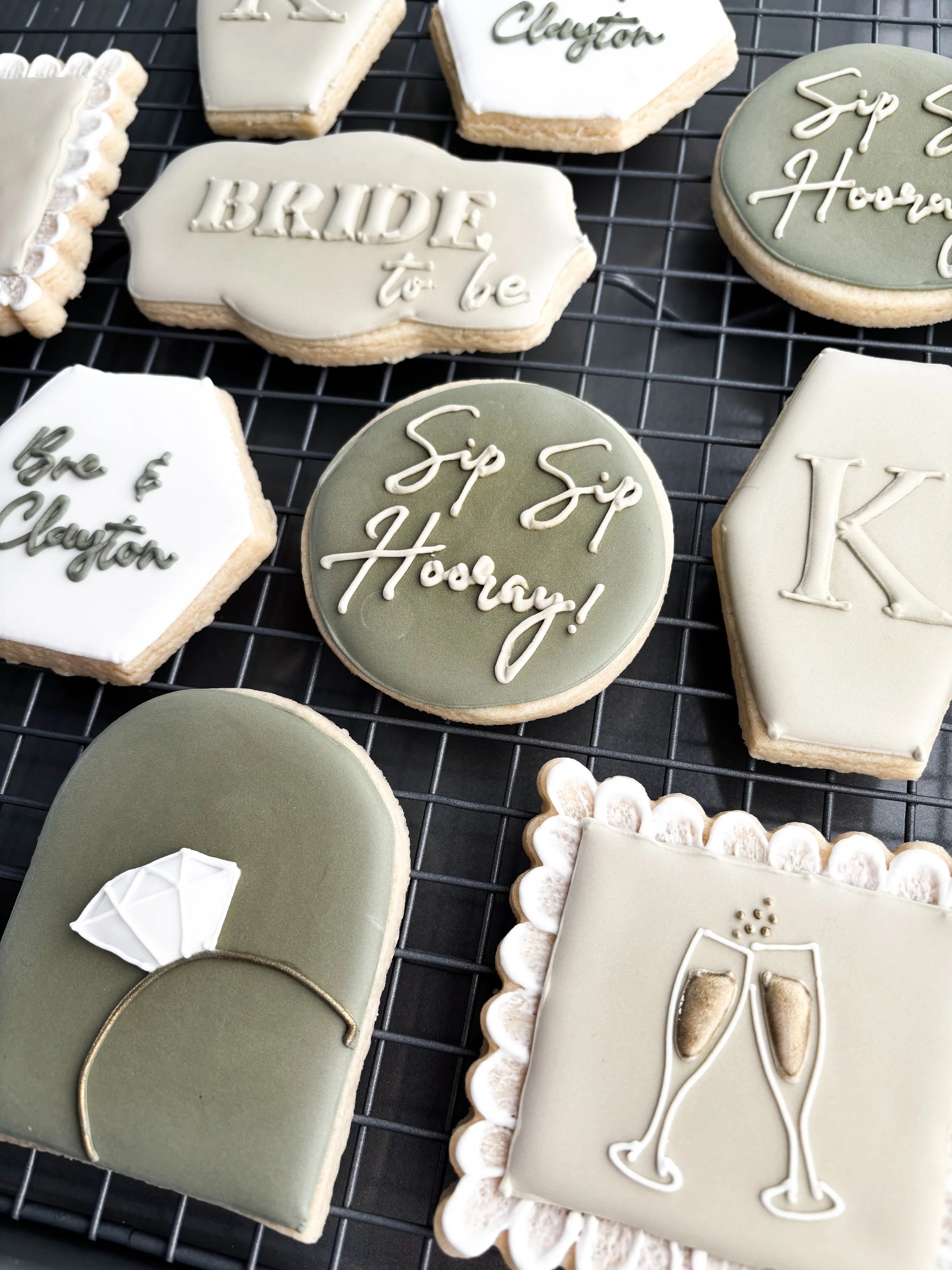 Decorative cookies with wedding-themed messages and designs, including rings, champagne glasses, and a diamond.