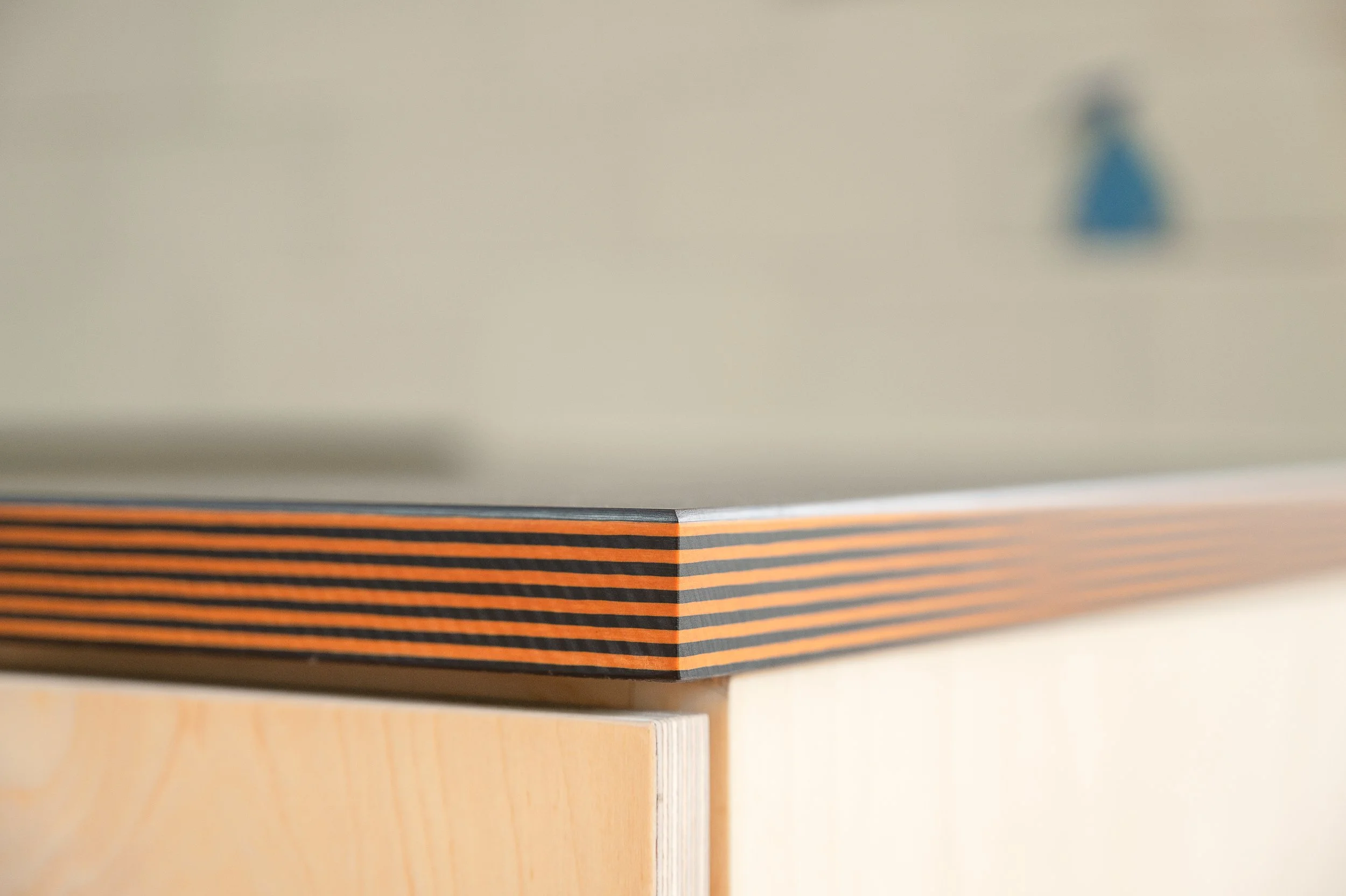 Close-up of the corner of a Richlite Hood countertop with a decorative striped edge, viewed from a side angle.
