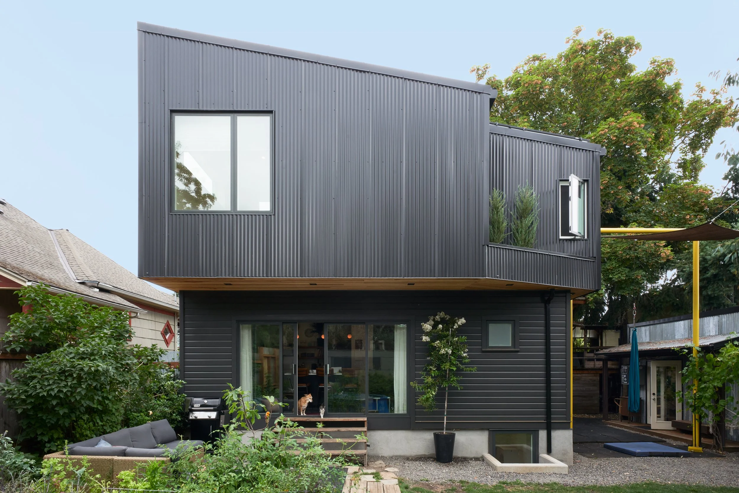 A view from the backyard shows off this house addition's interesting contrasting angles.