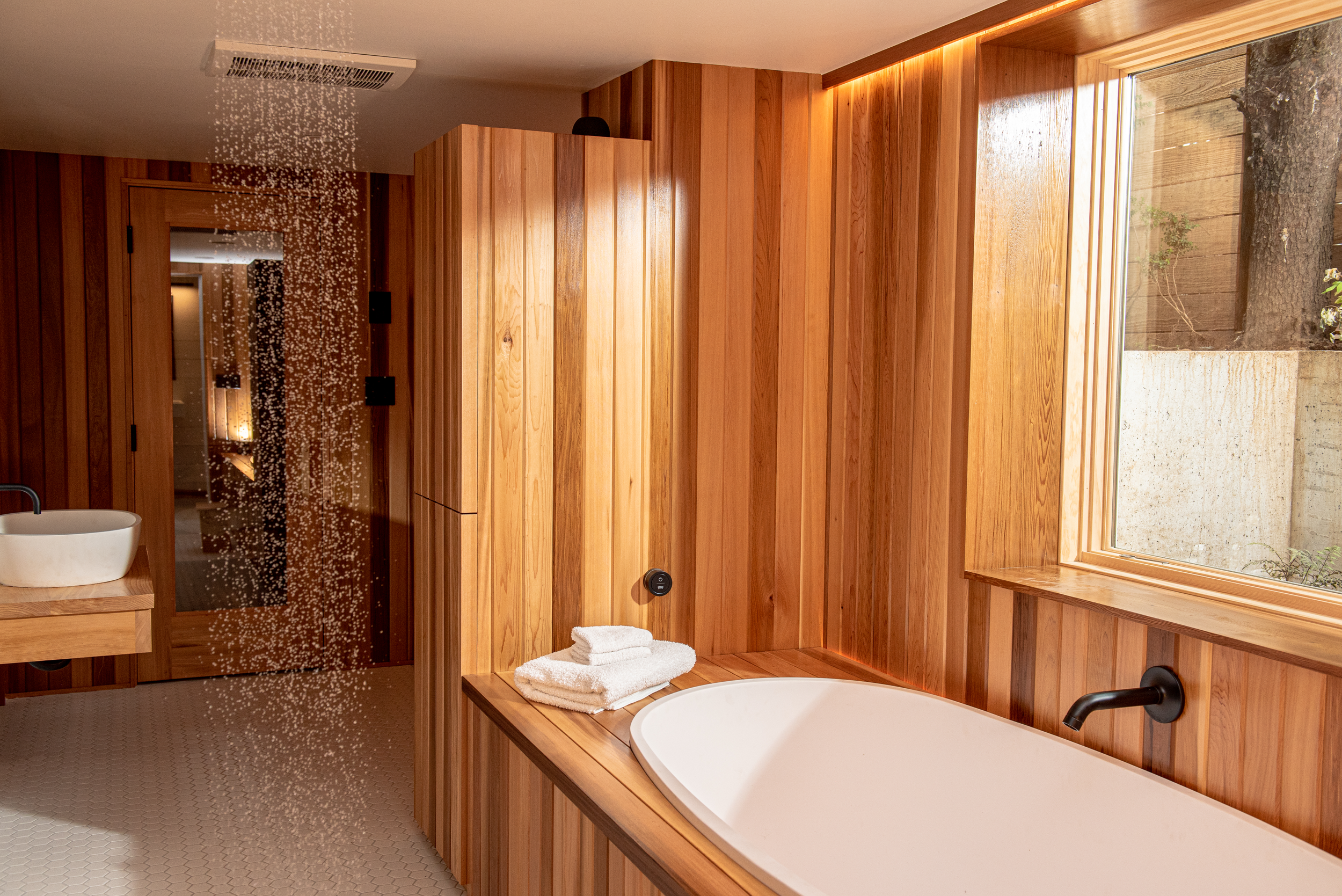 The remodeled shower is not enclosed, making it convenient to step out of the sauna cool off under the falling water.
