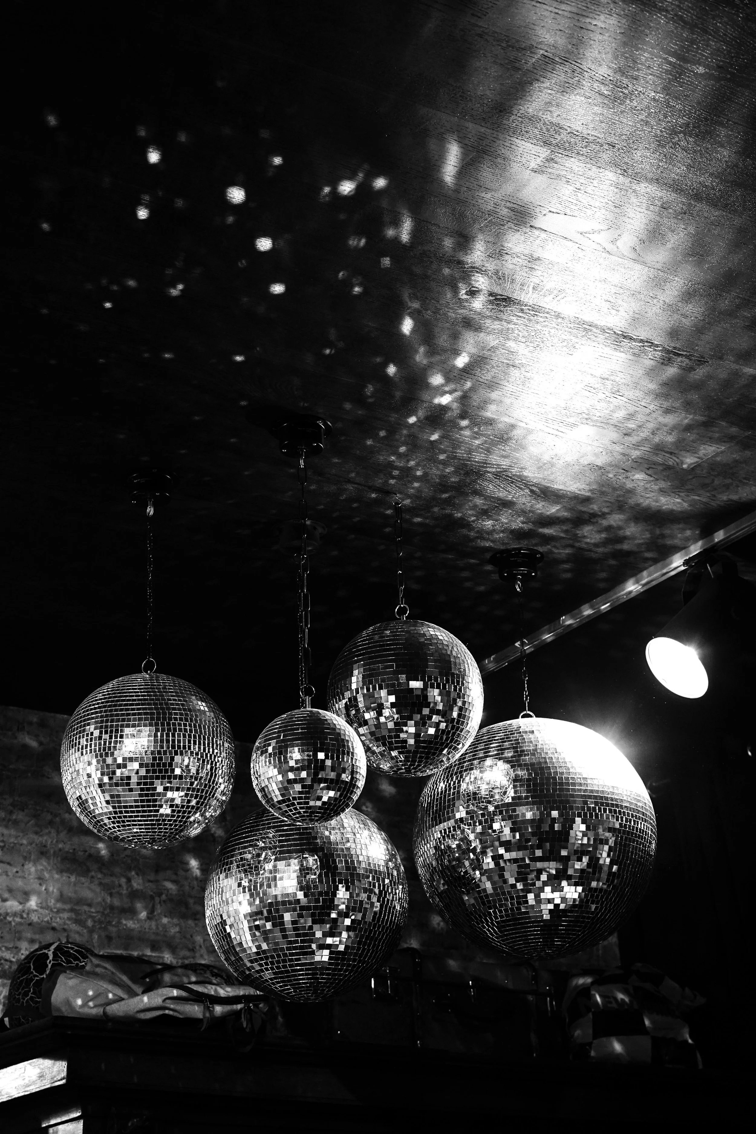 Hanging mirror disco balls creating sparkling party lighting effects for a modern event styled by Ignited Events in Dallas Fort Worth