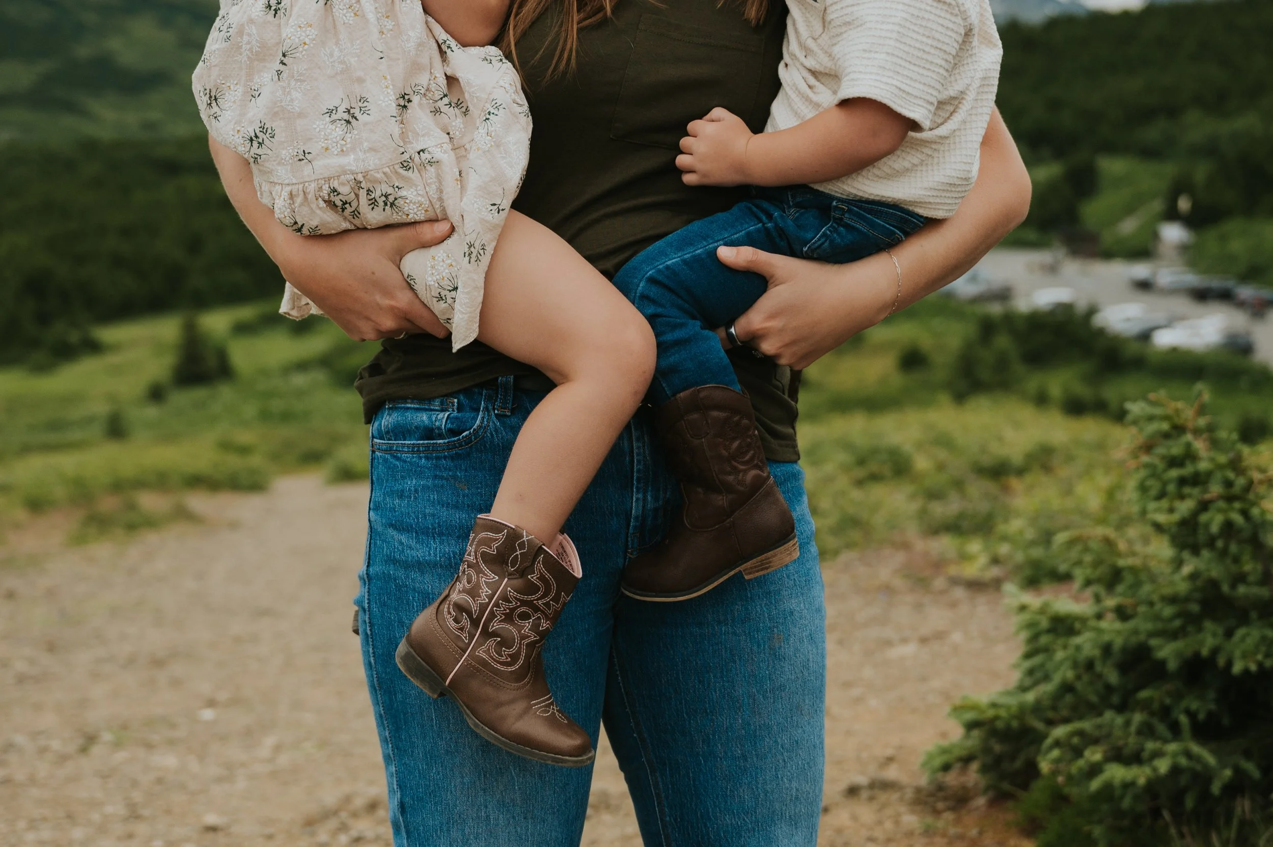 mom holding two toddlers in cowboy boots, closeup