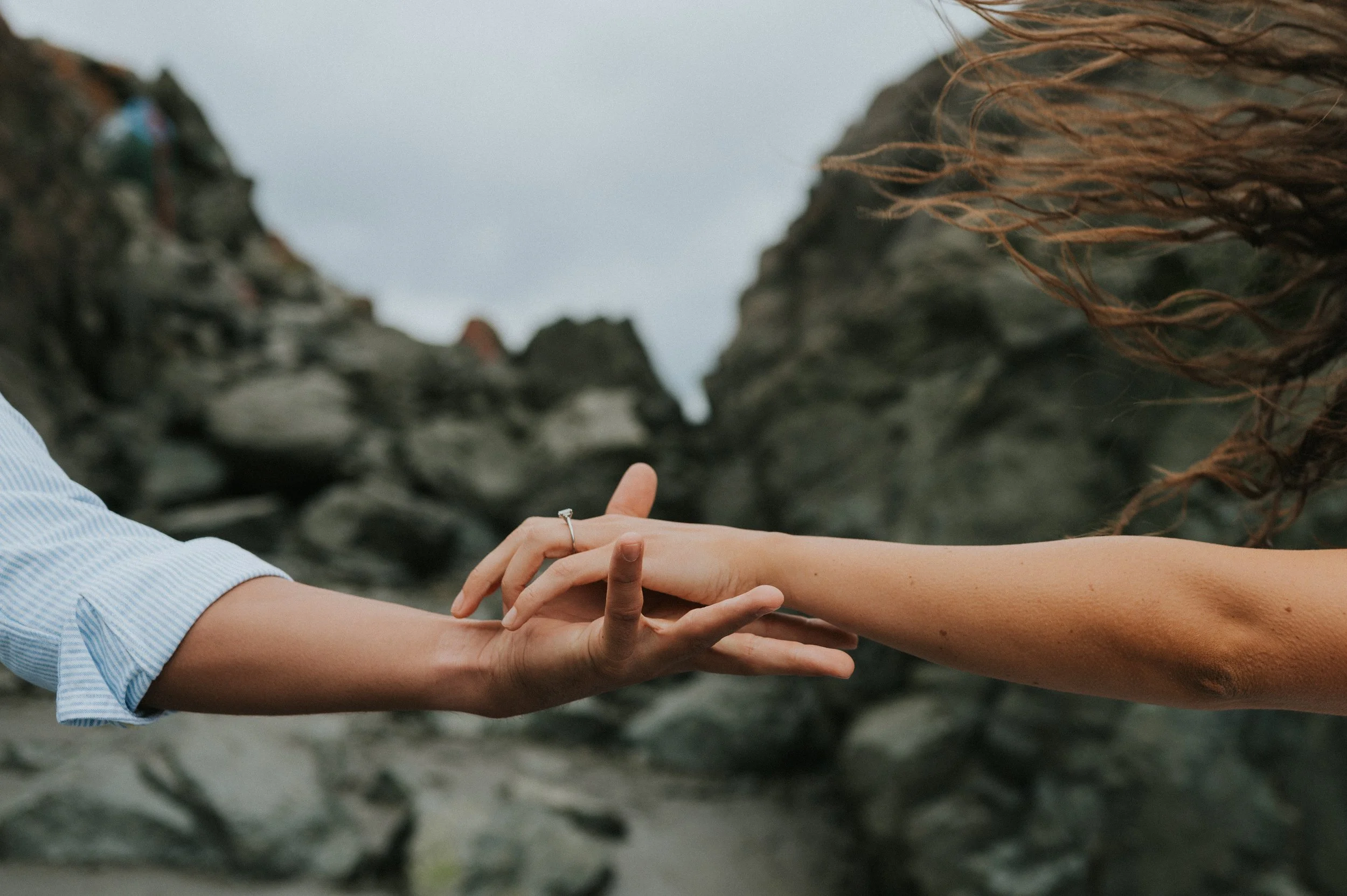 couple hands about to clasp with ring on