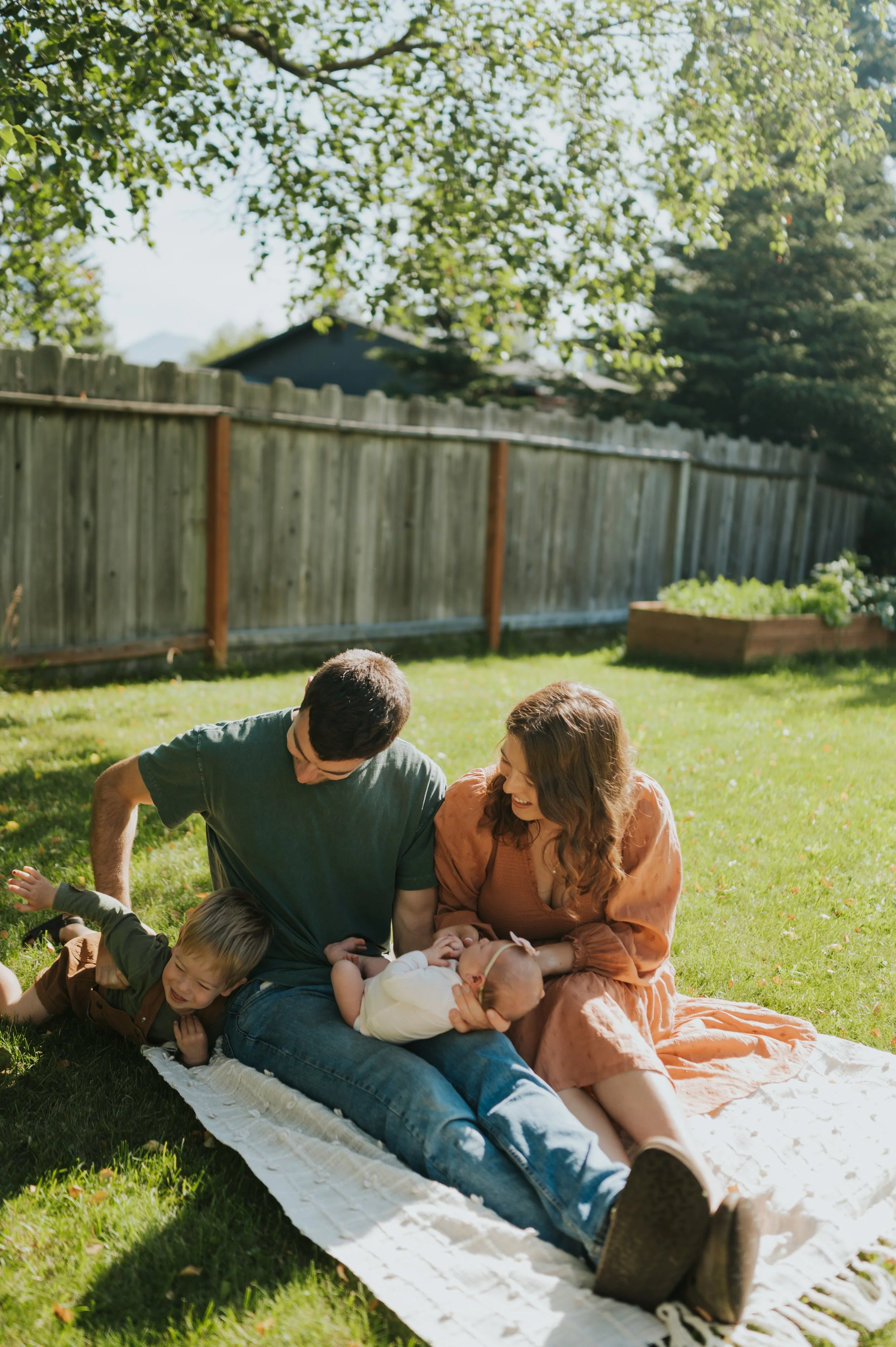family outside on picnic blanket