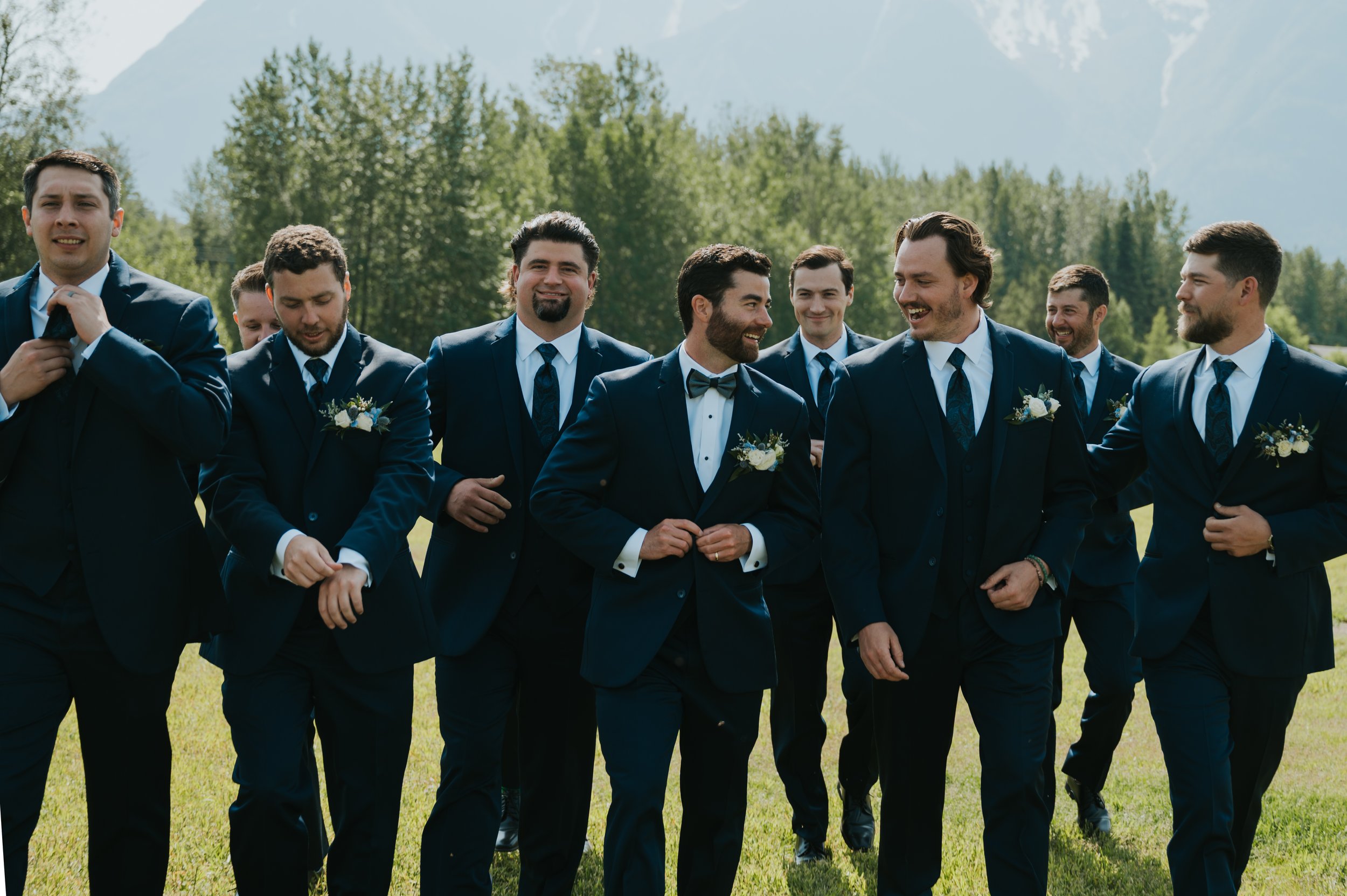 groom and groomsmen in front of mountains