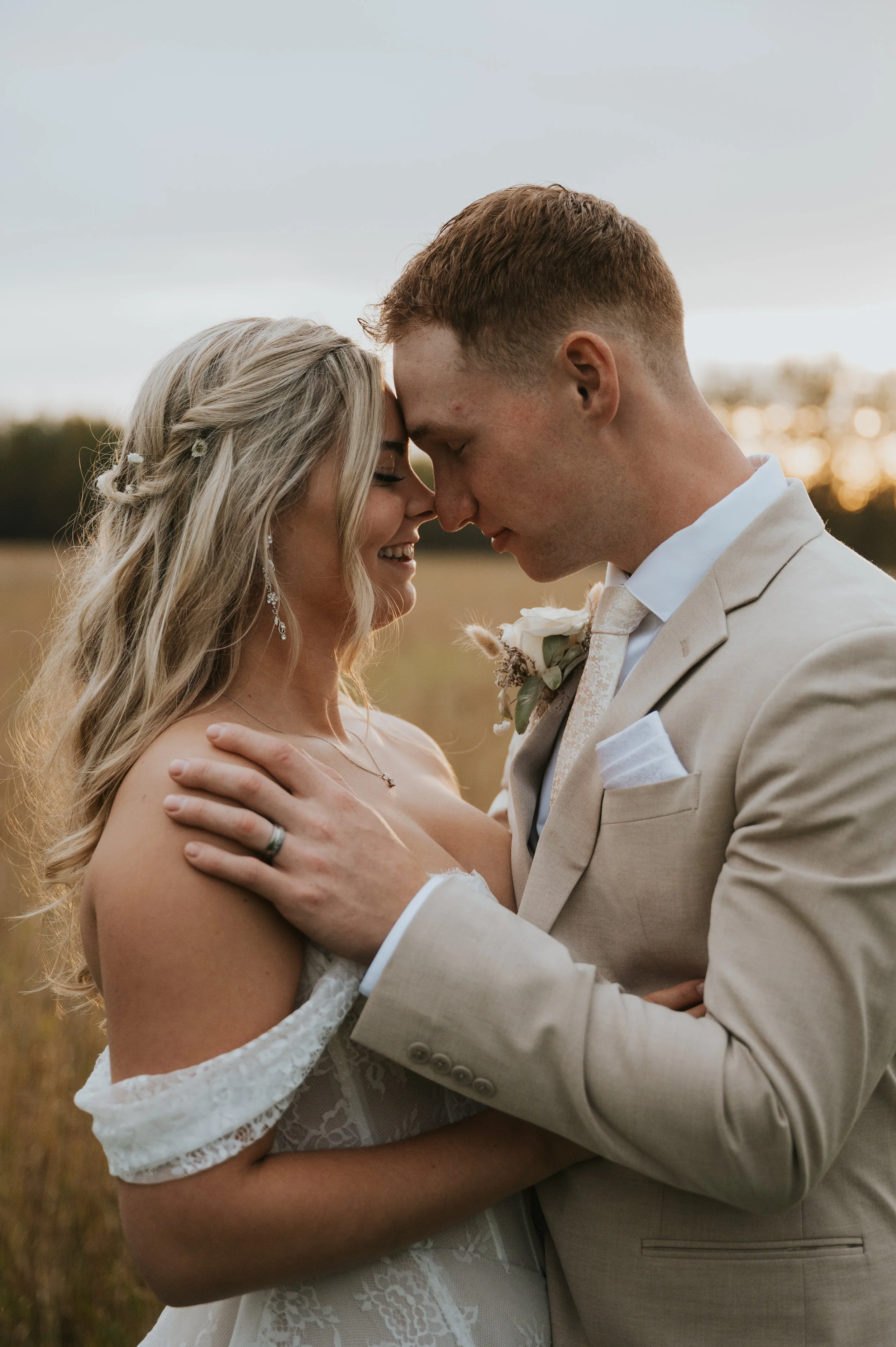 bride and groom touching noses golden hour