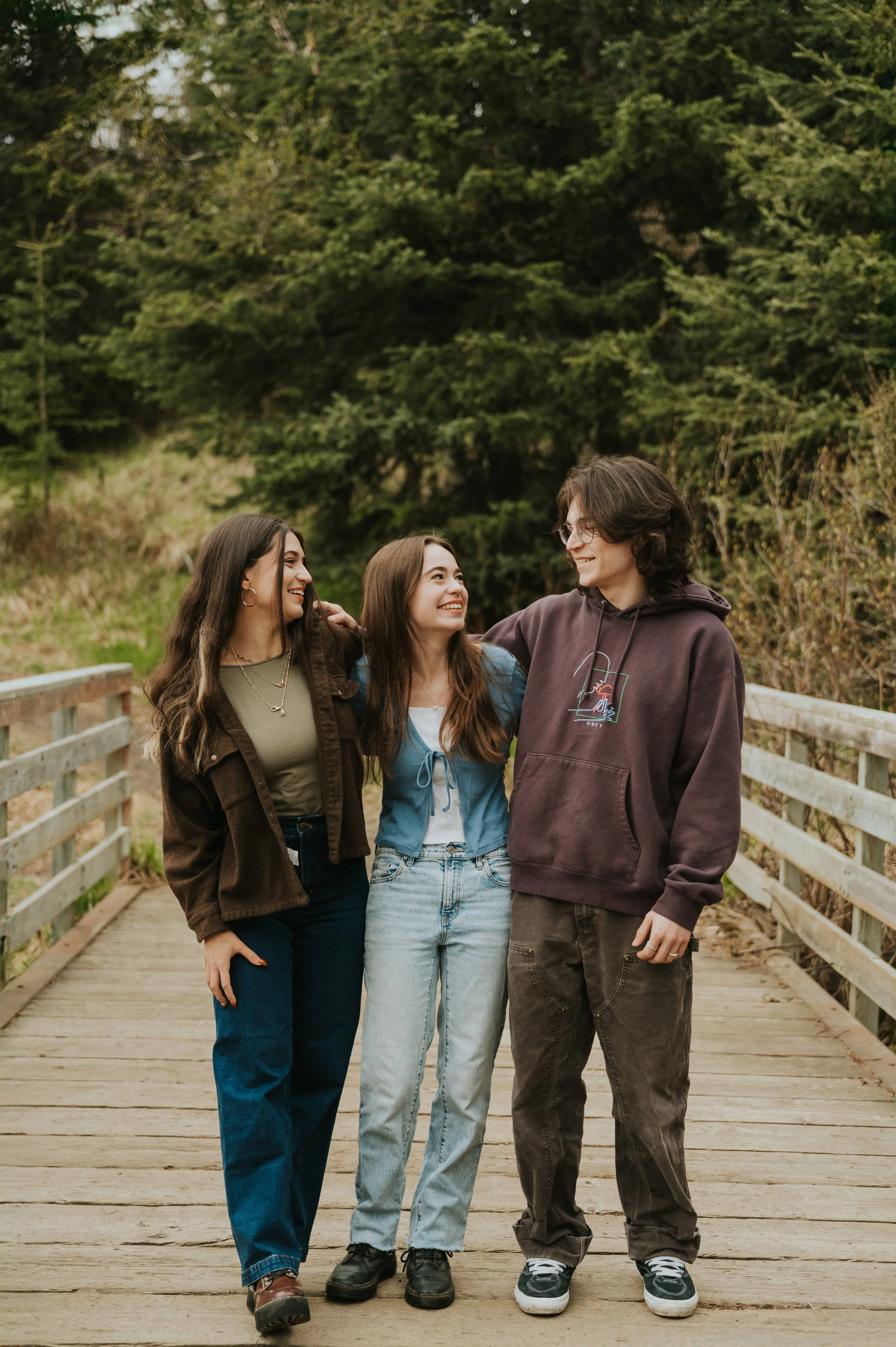 older sibling set smiling at eachother on bridge