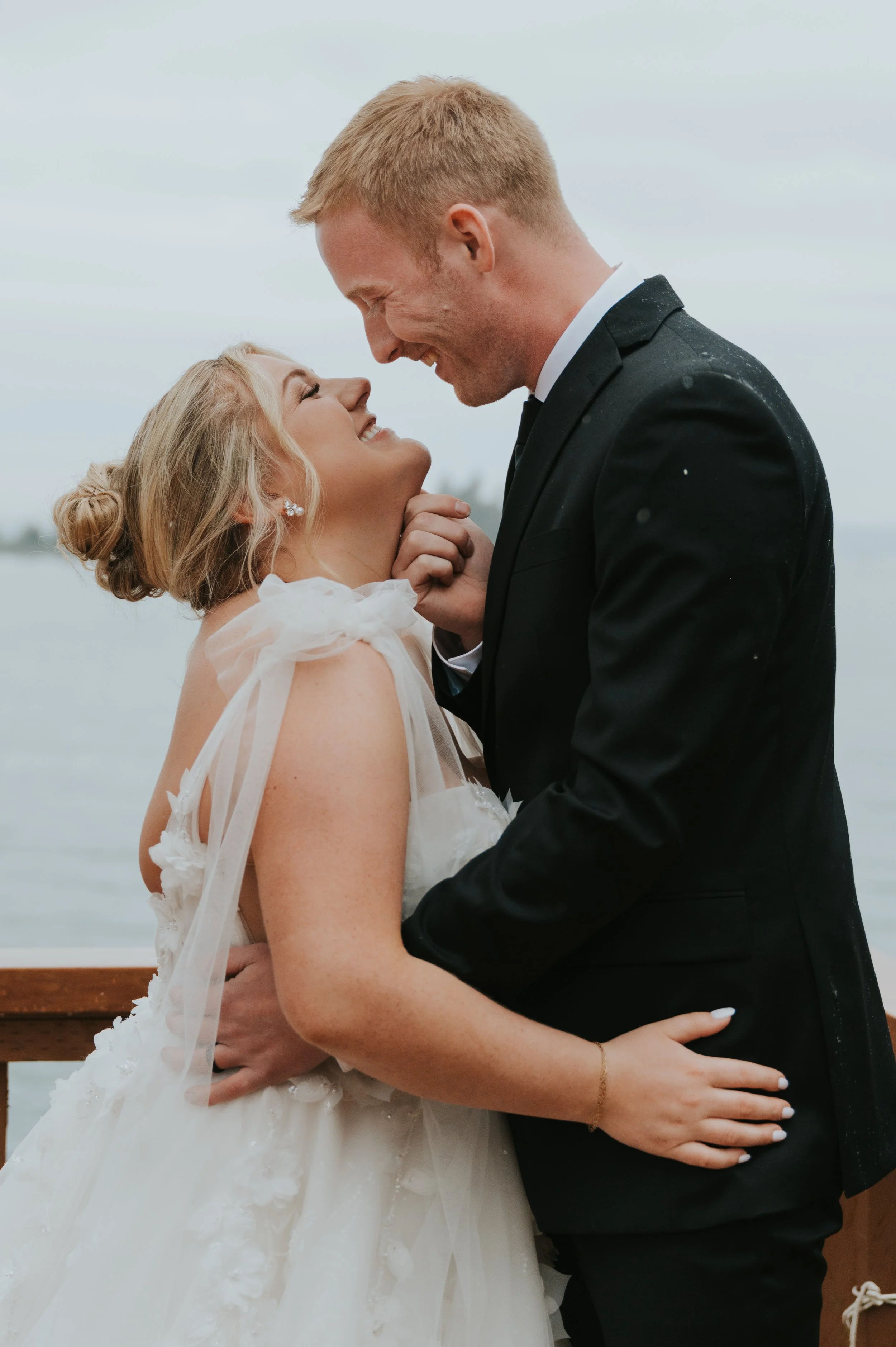 couple smiling at each other in wedding attire