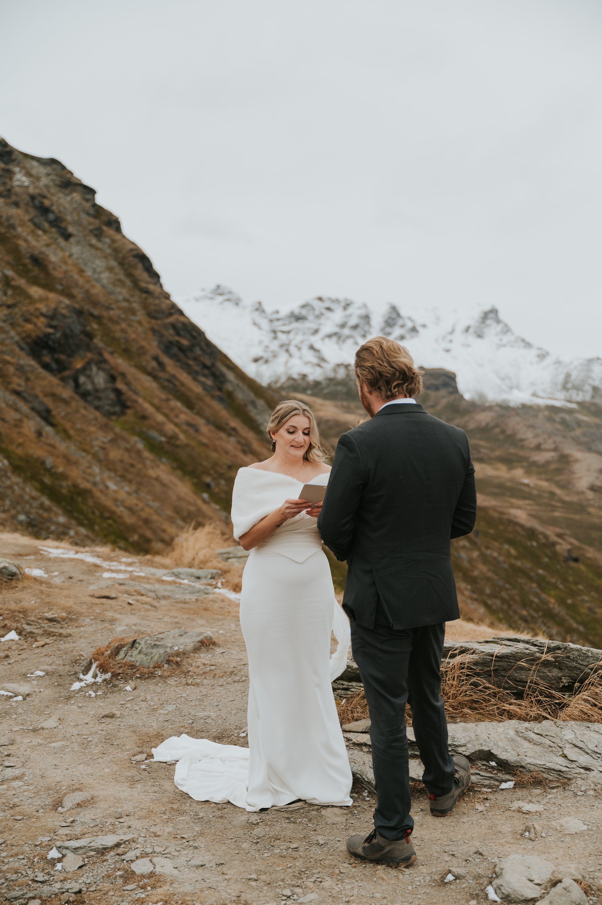 Image of couple reading vows on mountainside