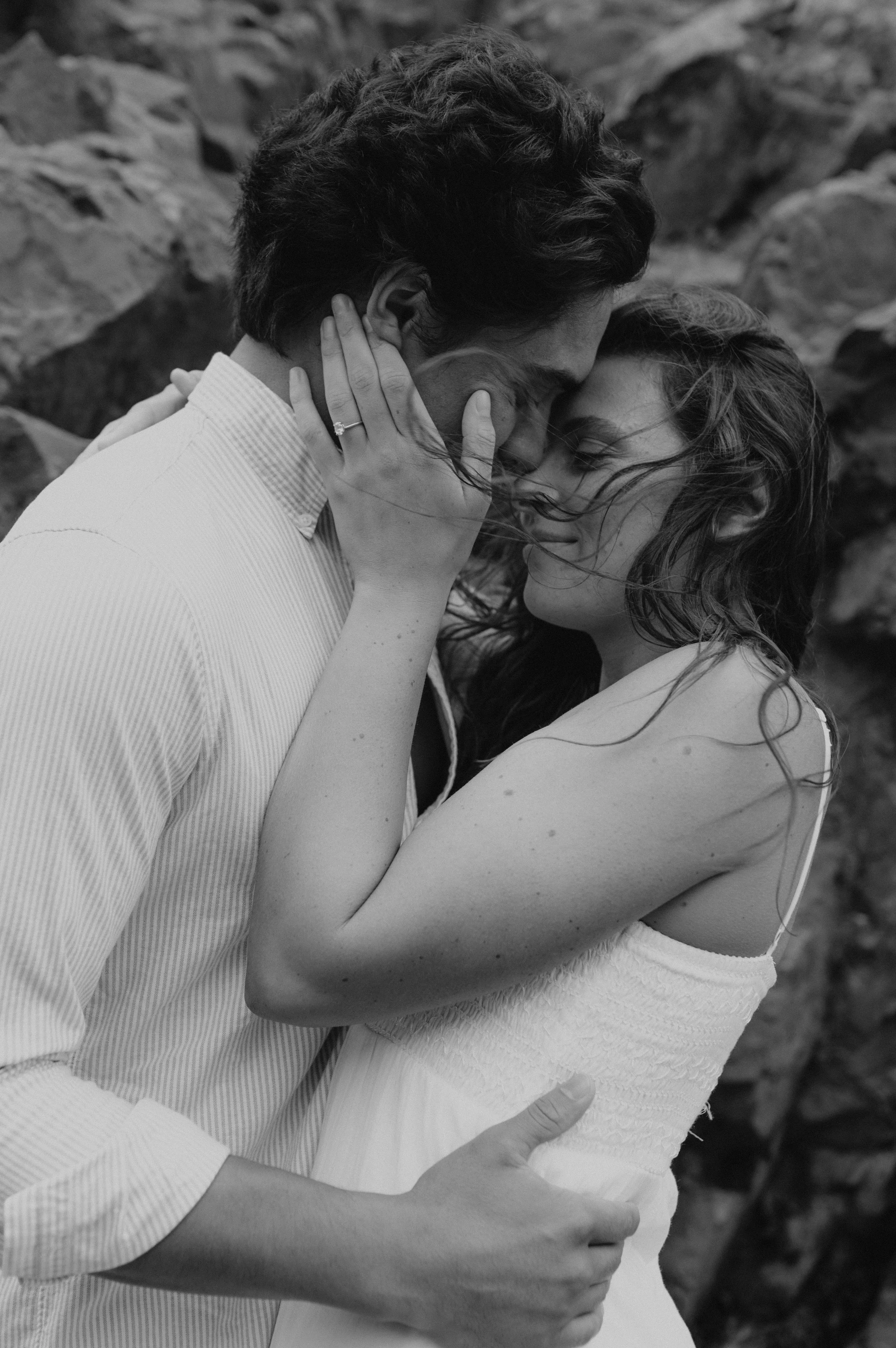 couple touching noses in wind black and white