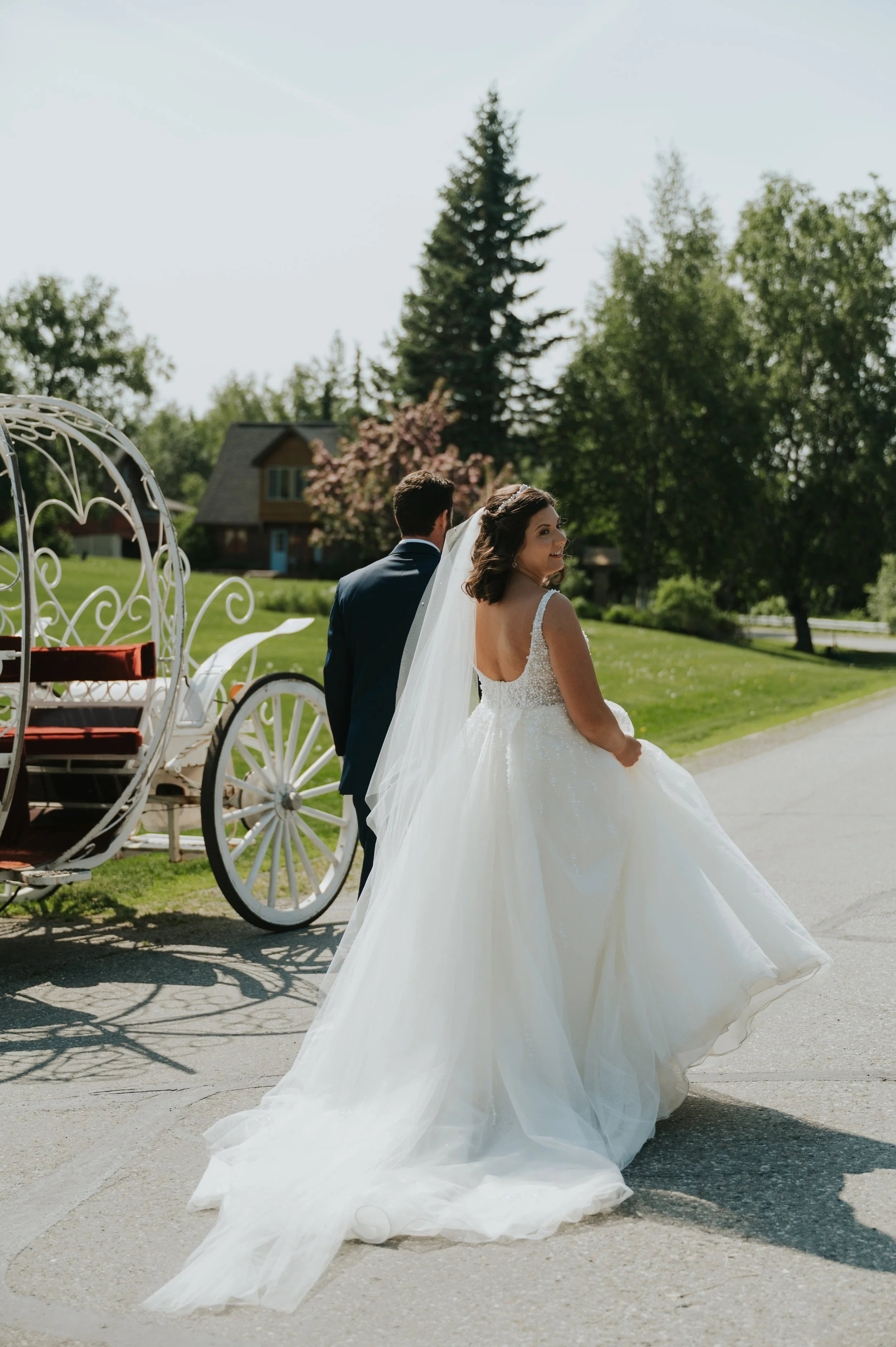 couple walking towards carriage in wedding attire