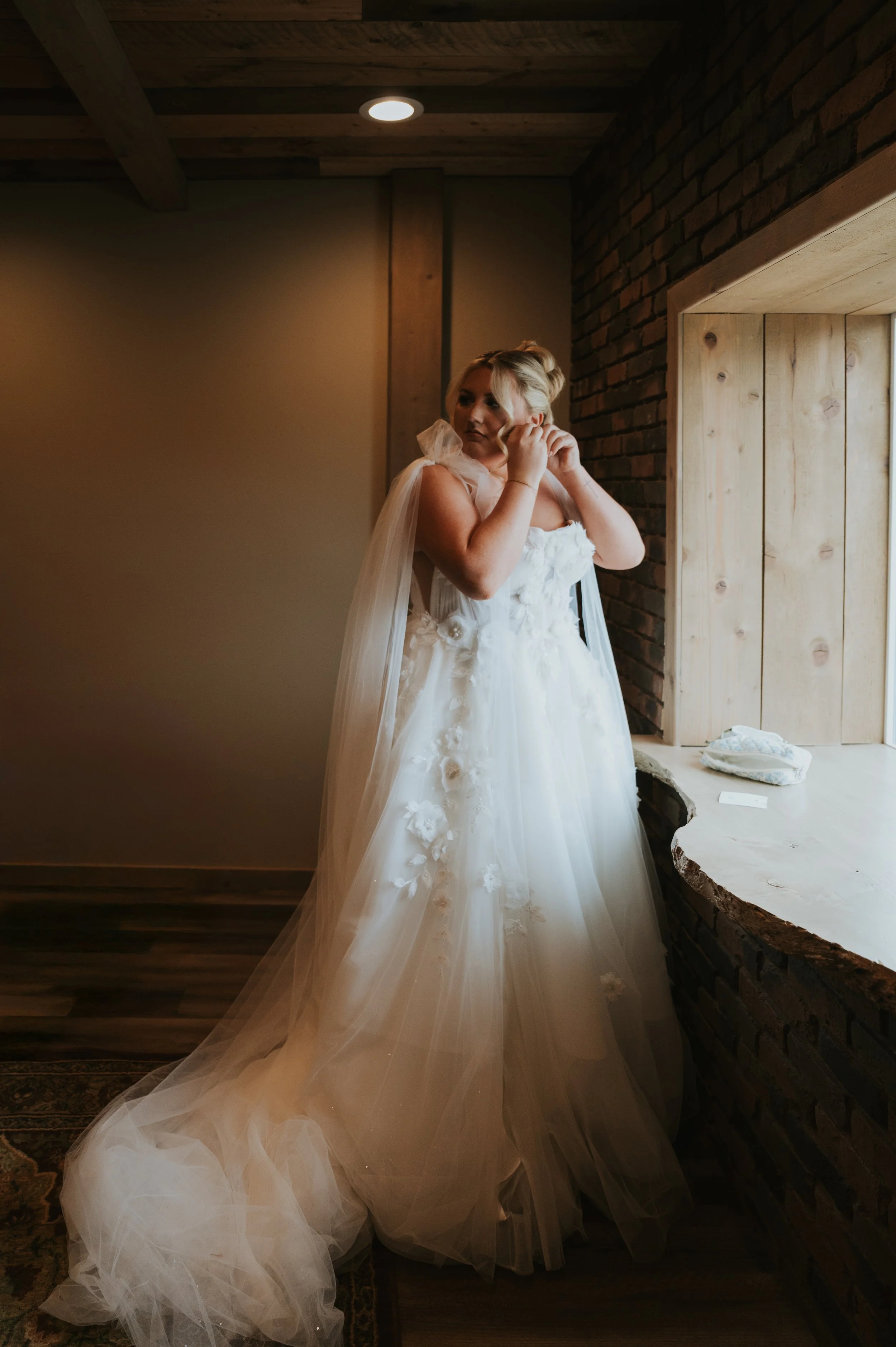 bride putting earrings in 