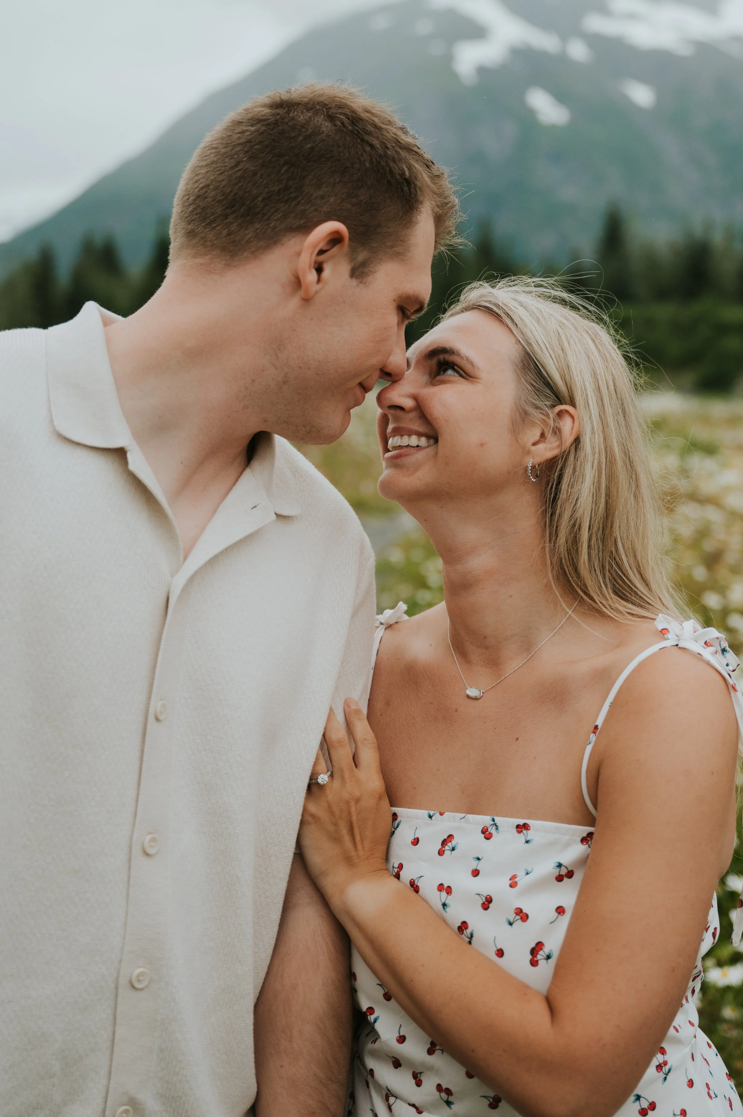 engaged couple in smiling at eachother